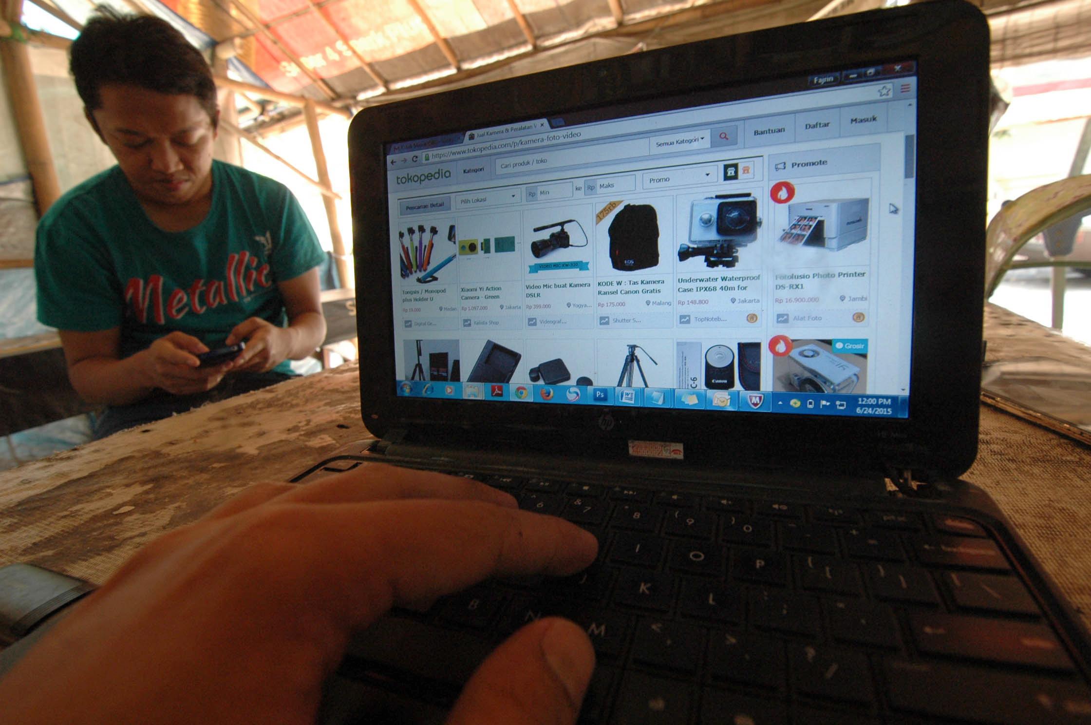 Warga menggunakan perangkat laptop untuk berbelanja daring.