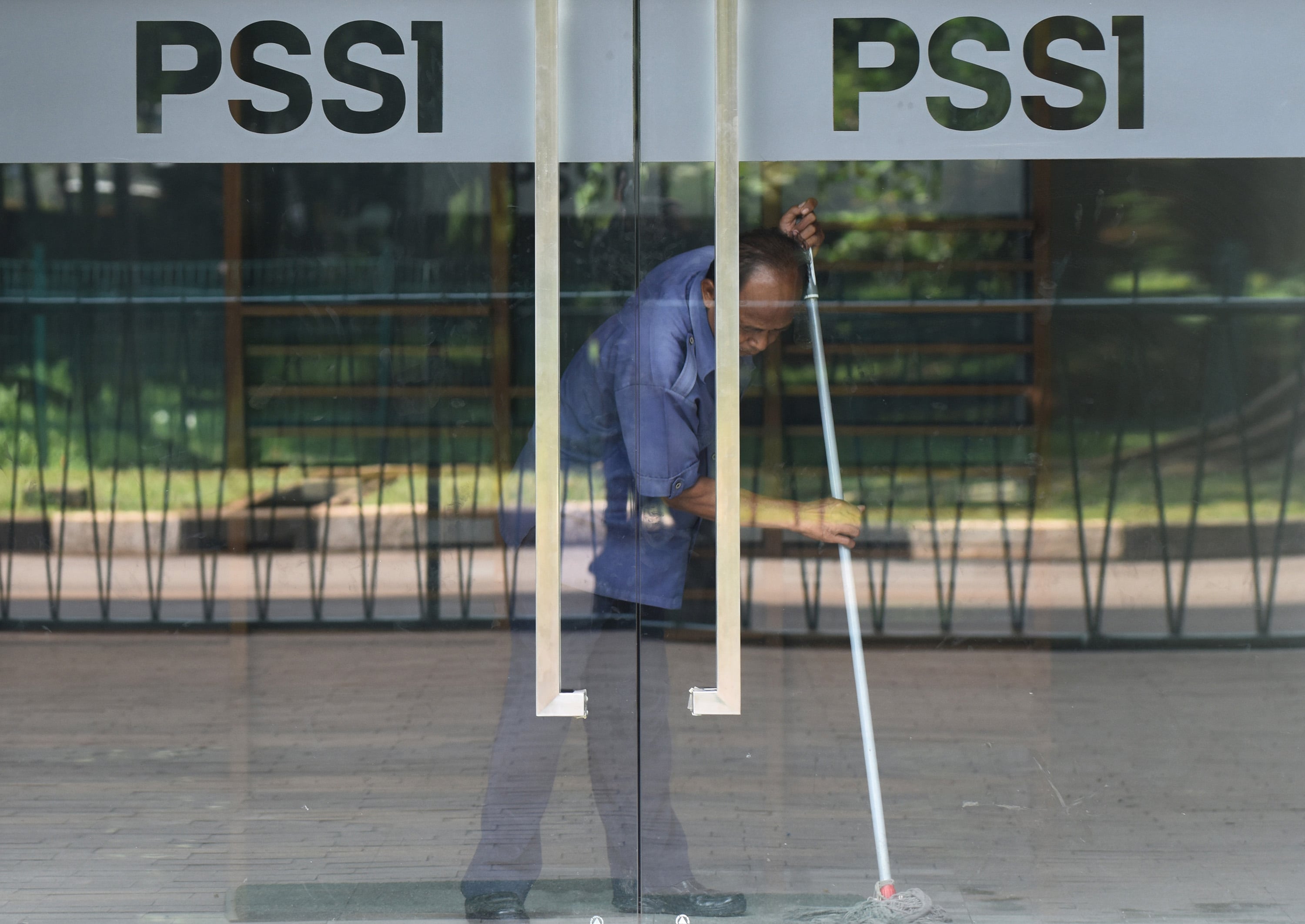 Seorang pekerja membersihkan kantor PSSI di Kompleks Stadion Utama Gelora Bung Karno, Jakarta