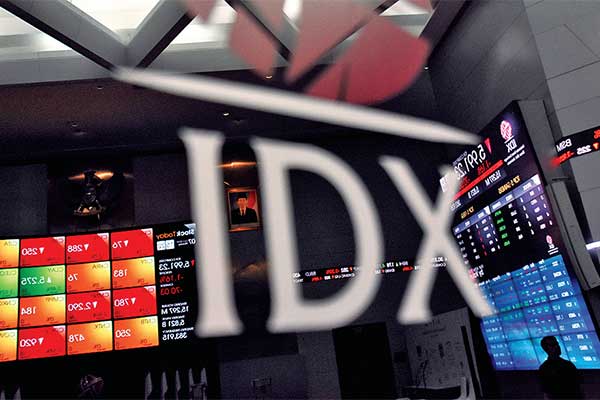 Pegawai melintas di depan layar pergerakan saham di Gedung Bursa Efek Indonesia, Jakarta, kemarin.