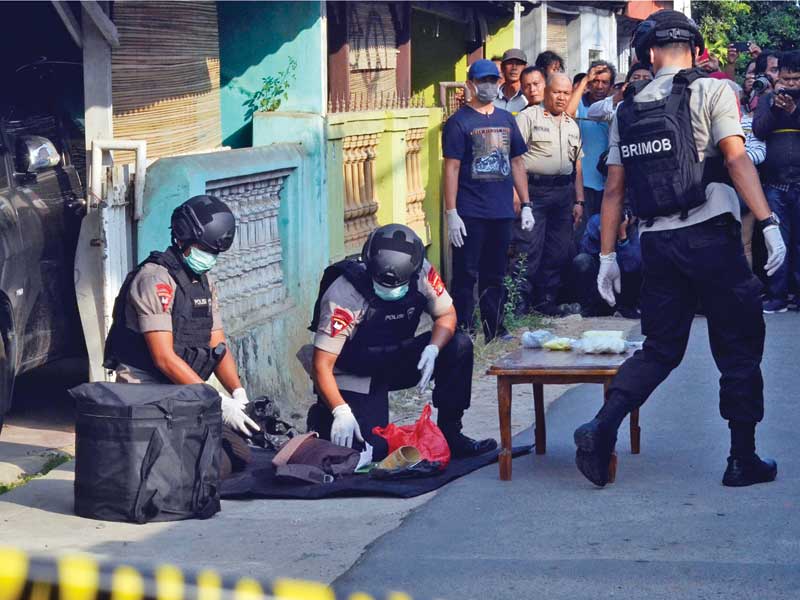 Personel Brimob Polda Lampung mengumpulkan sejumlah barang bukti seusai menggeledah rumah milik orangtua terduga teroris di Bandar Lampung.