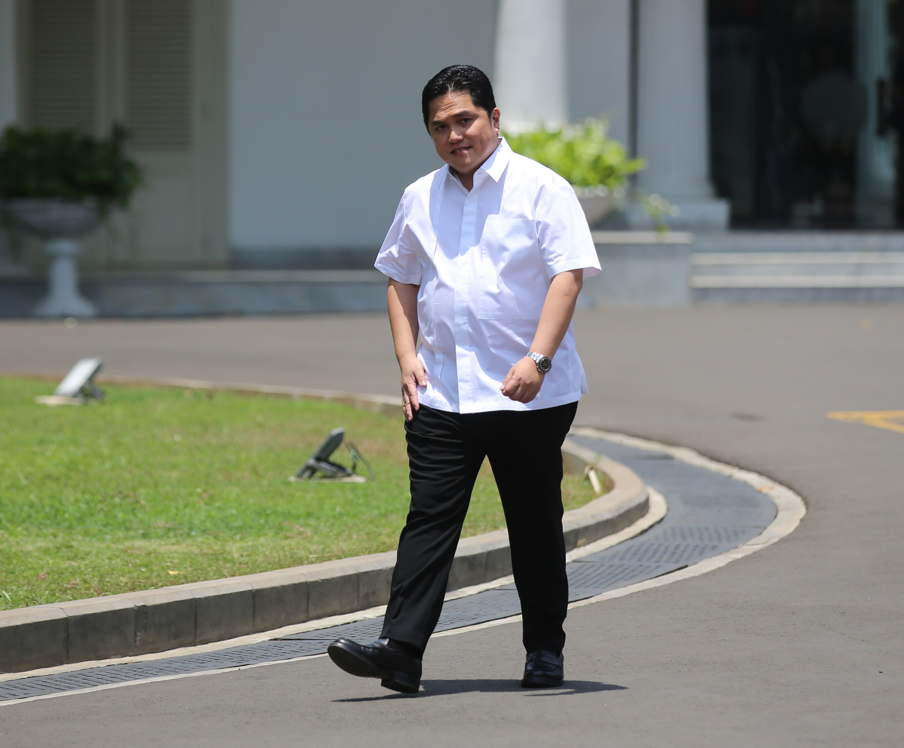 Erick Thohir melambaikan tangannya saat berjalan memasuki Kompleks Istana Kepresidenan, Jakarta, hari ini.