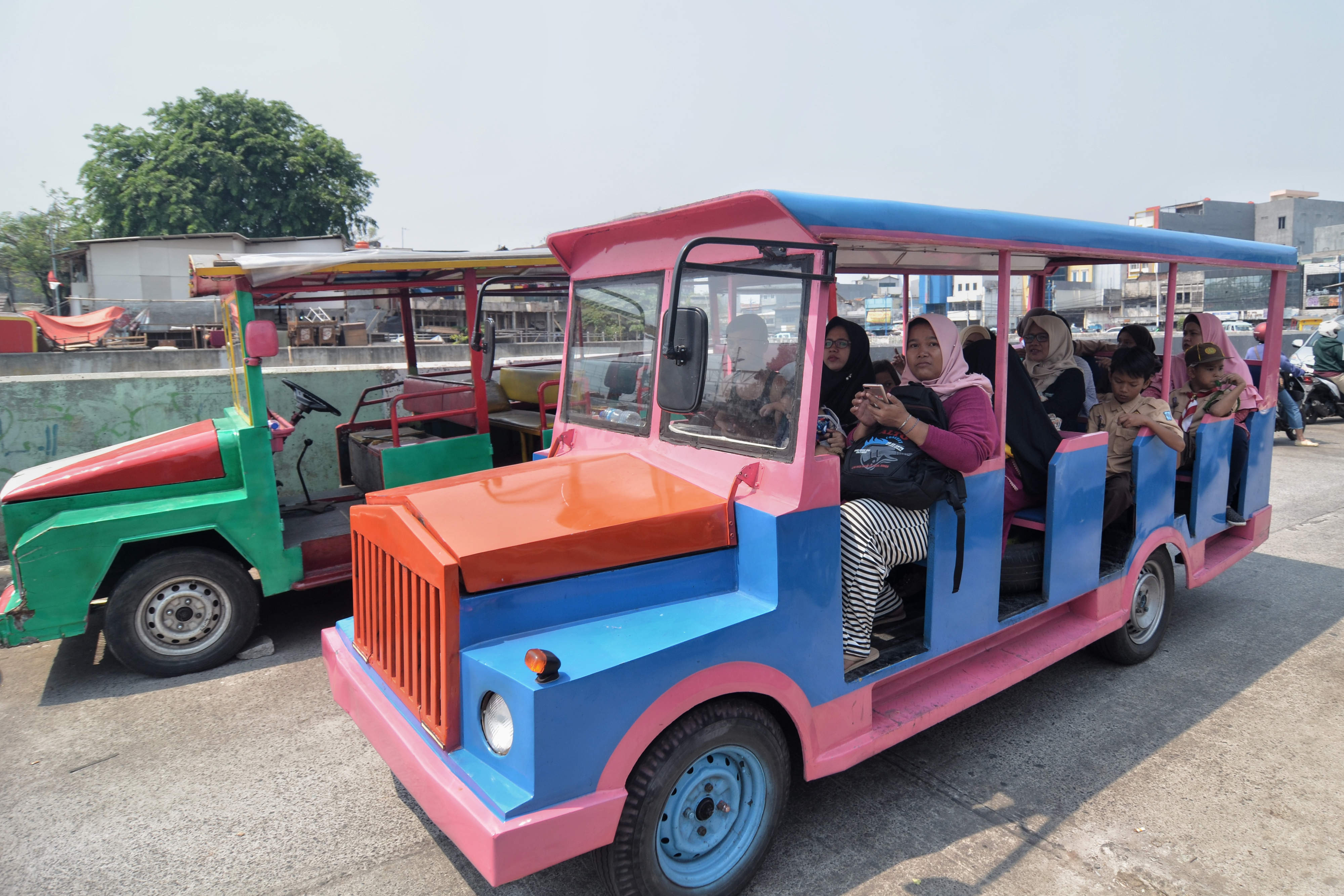 Warga menaiki odong-odong di wilayah Kampung Pulo, Jakarta Timur, Kamis (24/10).