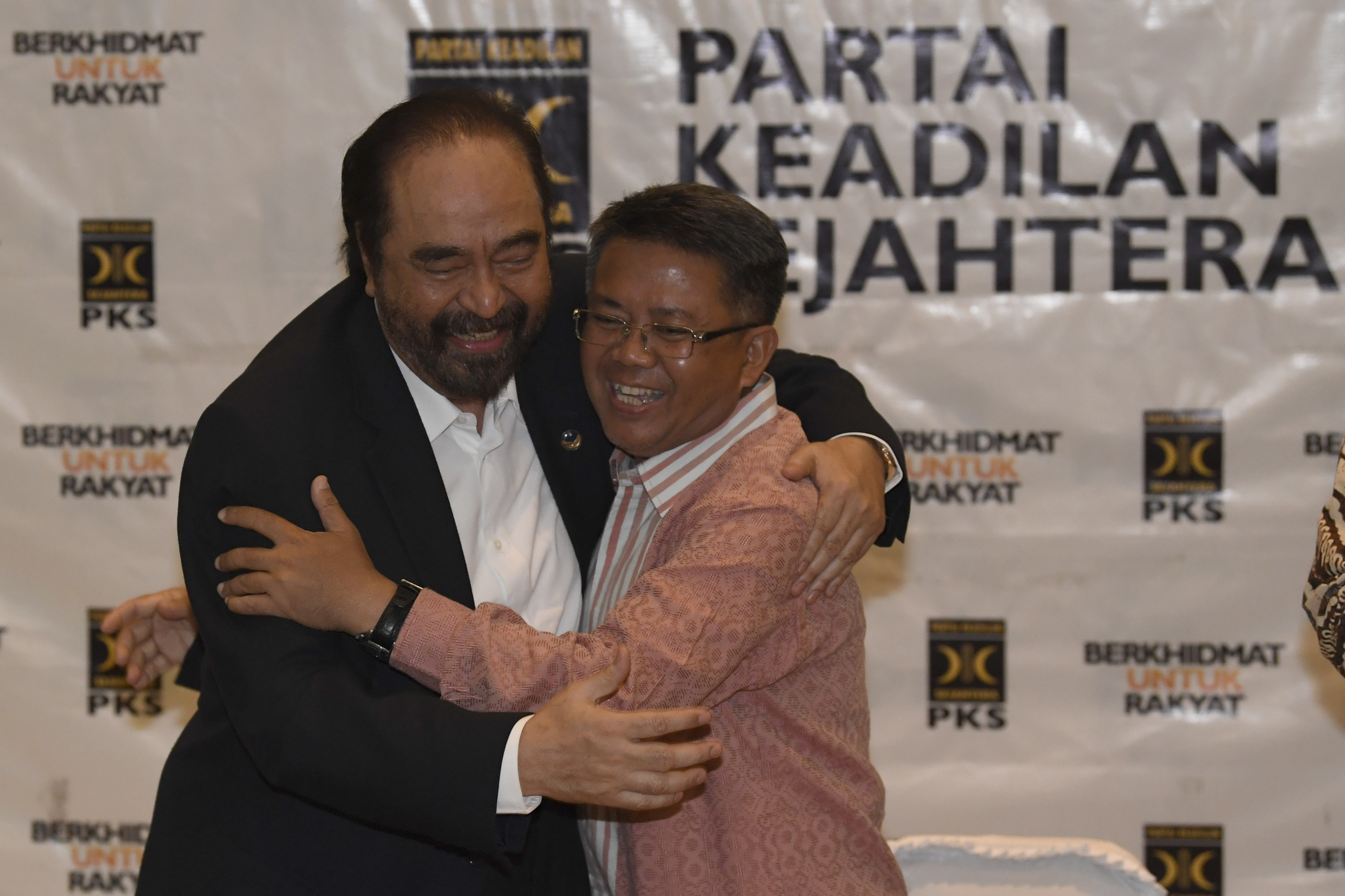 Ketua Umum NasDem Surya Paloh (kiri) berpelukan dengan Presiden PKS Sohibul Iman