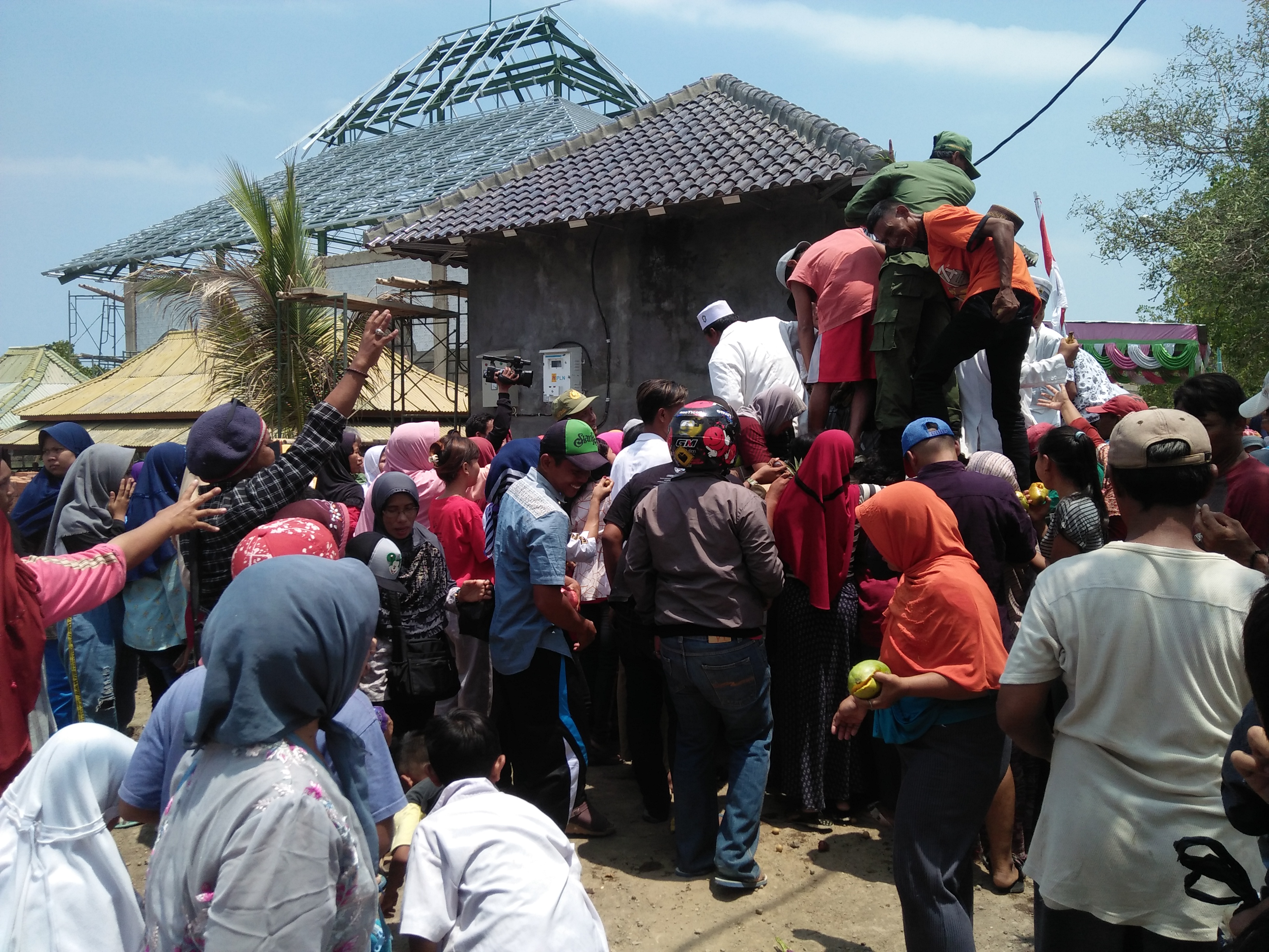 Warga berebut hasil bumi di acara upacara gant kelambu makam Syeh Junaedi Al Bagdadi di Desa Randusanga Wetan, Brebes, Selasa (12/11/2019). 