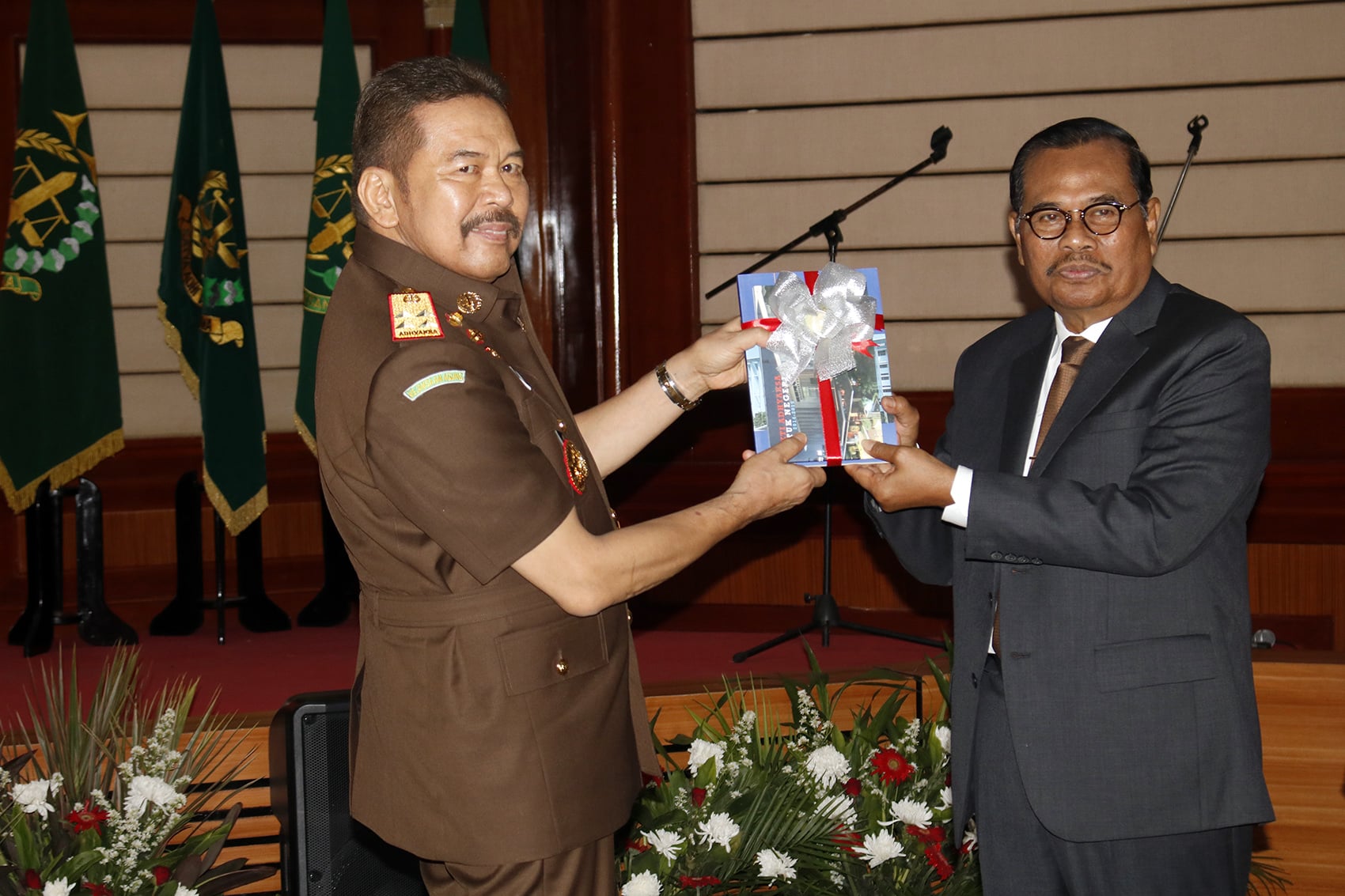 Jaksa Agung periode 2014-2019 HM Prasetyo (kanan) memberikan buku Bakti Adhyaksa kepada Jaksa Agung yang baru ST Burhanuddin (kiri).