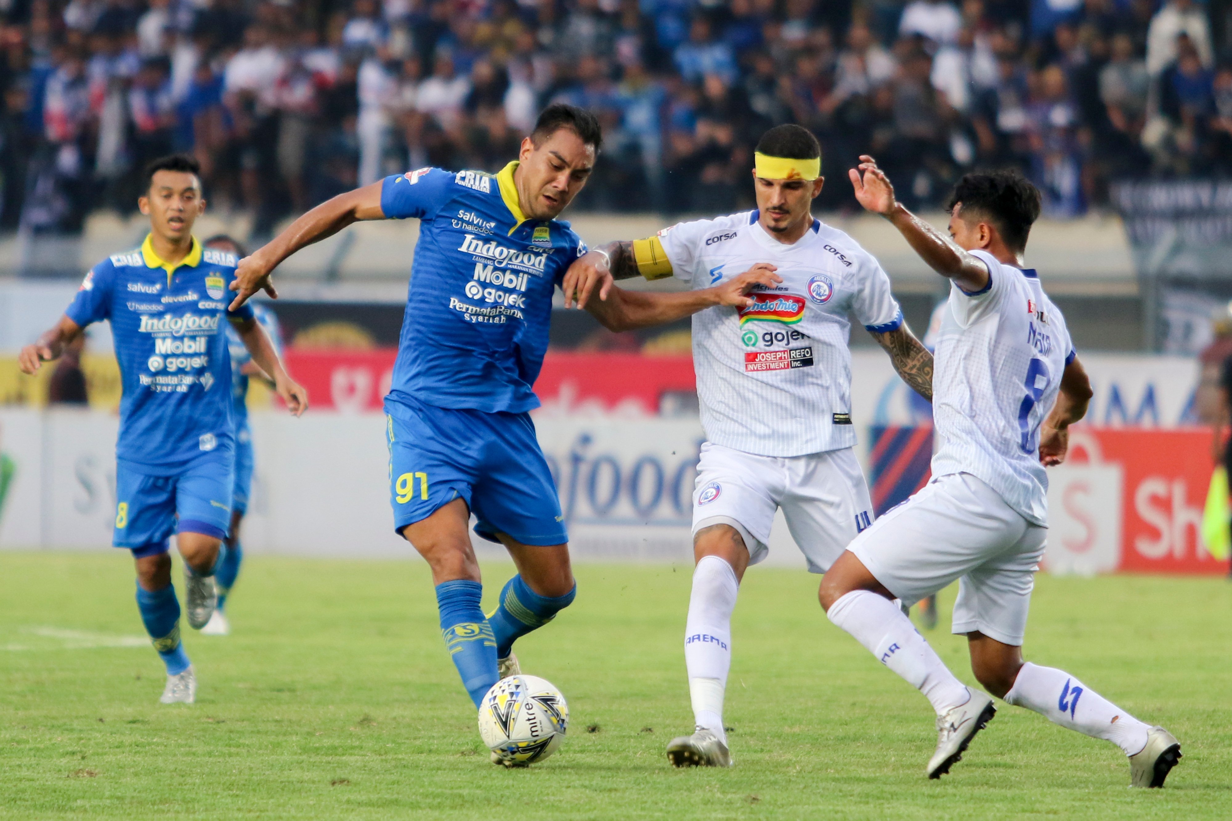  Pesepak bola Persib Bandung David Omid Nazari (kedua kiri) berebut bola dengan dua pesepak bola Arema FC Nasir (kanan)  