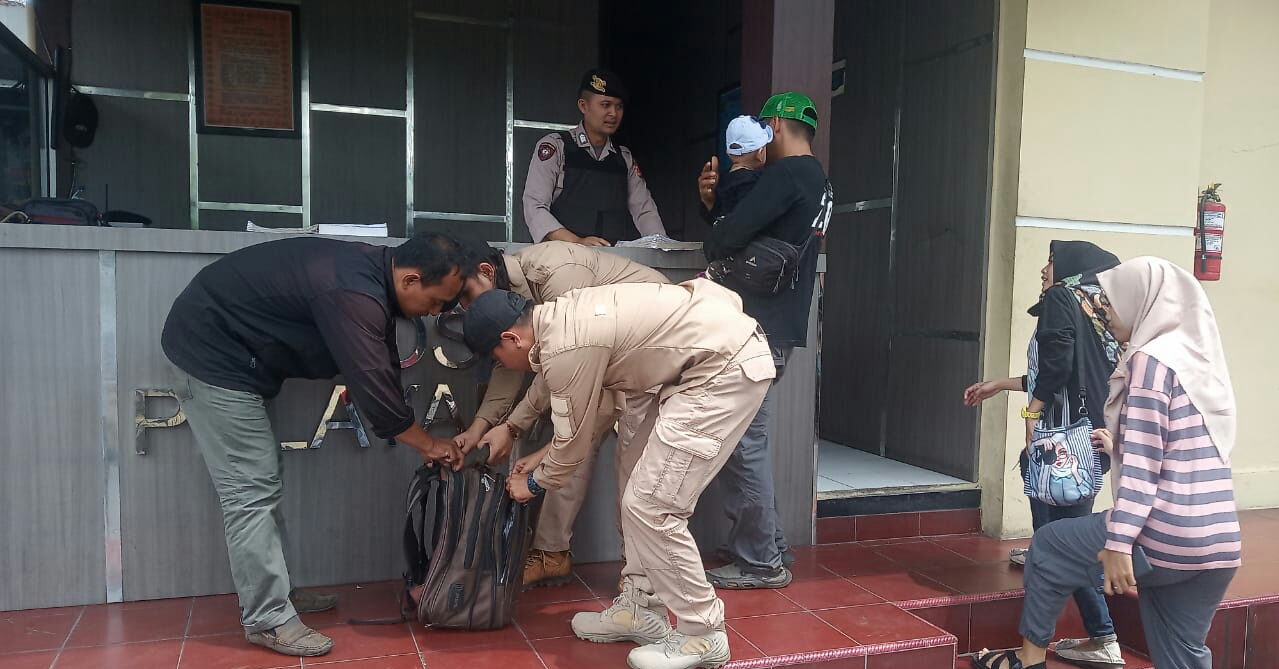 Petugas jaga di Polres Tasikmalaya memeriksasecara teliti  barang-barang milik tamu yang berkunjung.