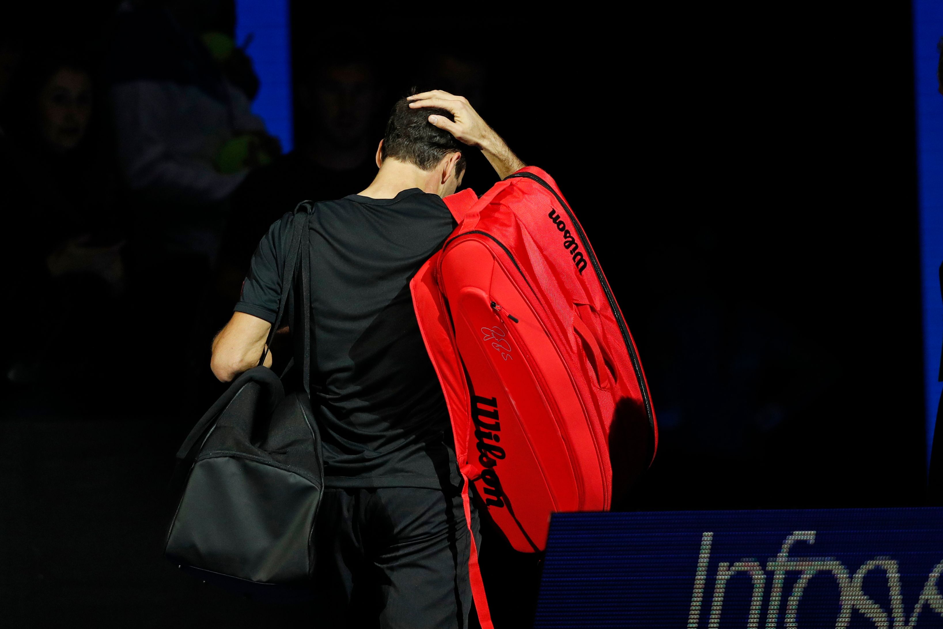 Roger Federer memegang kepala dan tampak kecewa setelah dikalahkan Dominic Thiem di laga pembuka ATP Finals 2019.   