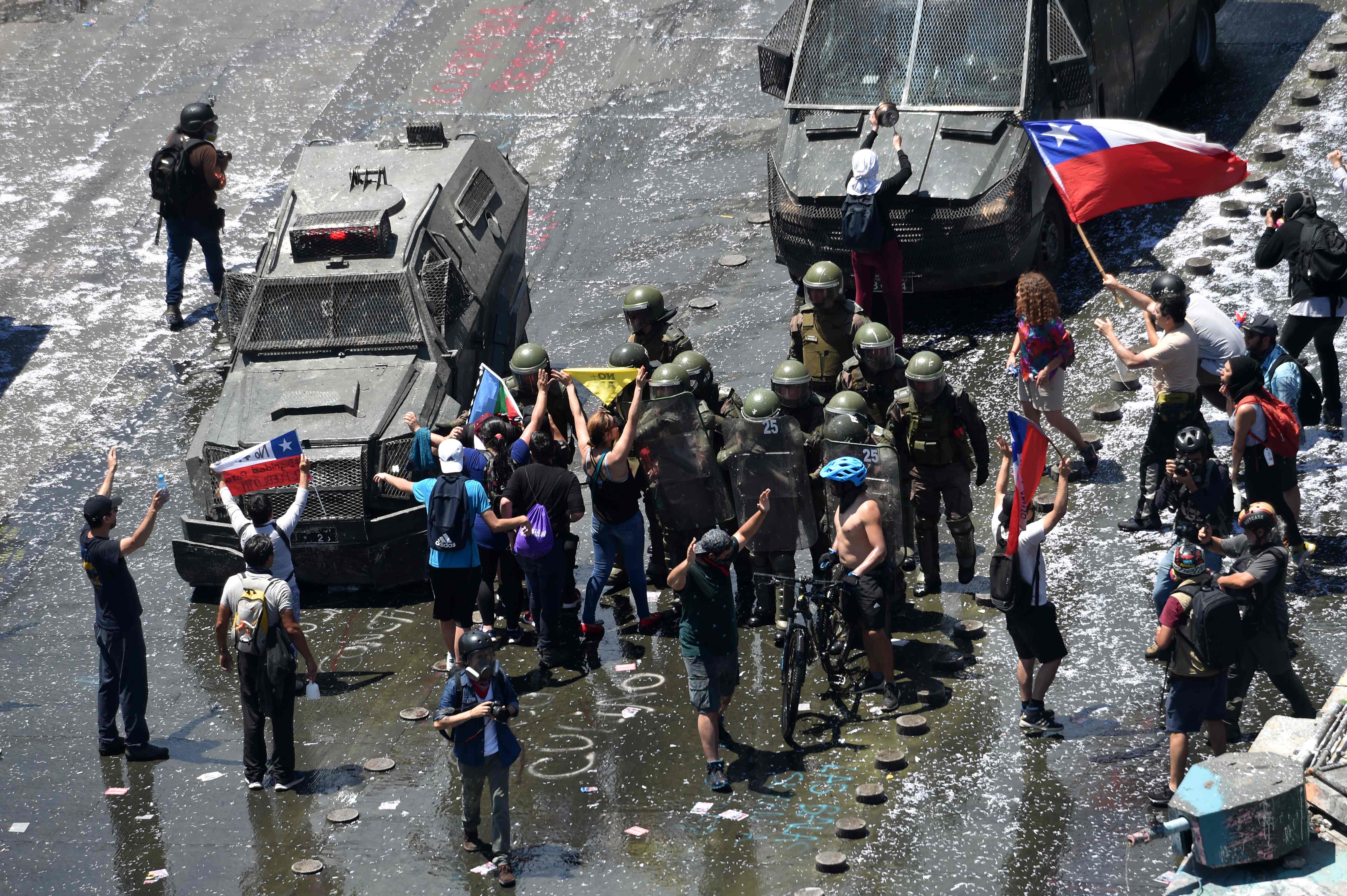 Demonstran melakukan aksi di depan polisi antihuru-hara di Santiago, Cile