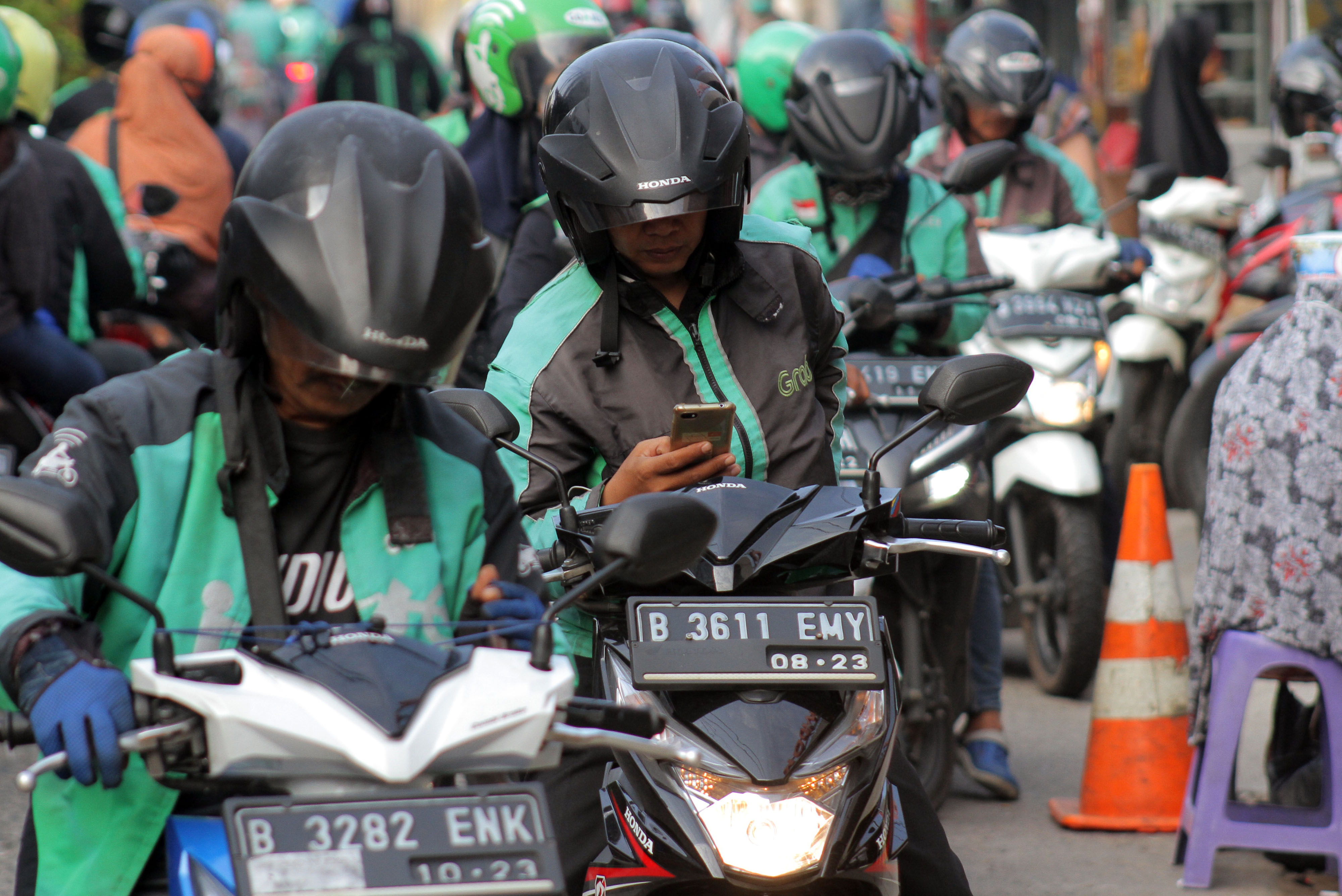 Sejumlah pengemudi ojek daring (online) menunggu penumpang di depan Stasiun Pondok Cina, Kota Depok,