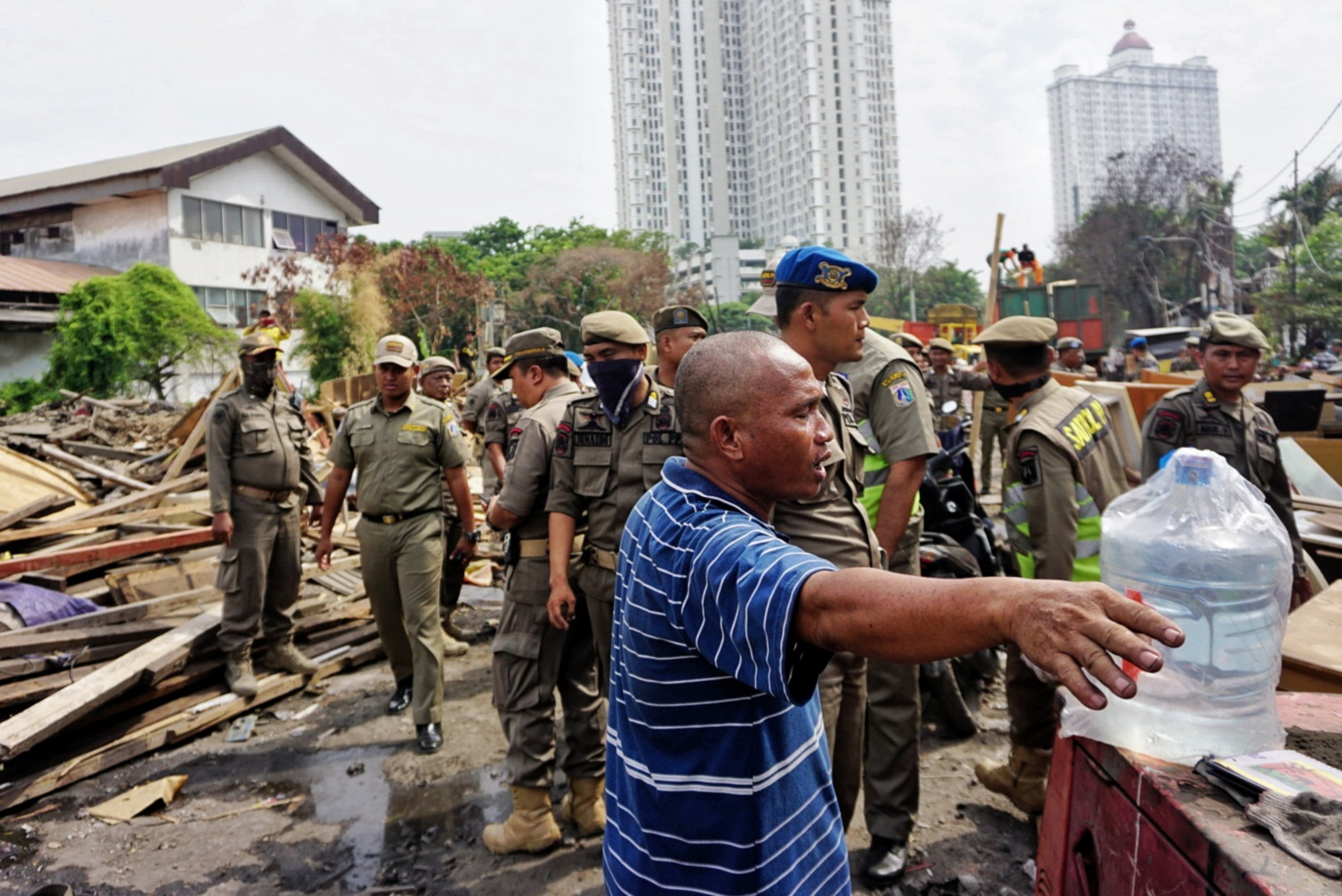 Petugas membongkar bangunan semi permanen di pinggiran Kali Sunter, Jakarta Utara.