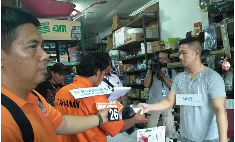 Tersangka penyiraman cairan kimia FY memperagakan membeli bahan kimia soda api di toko bangunan dalam gelar rekonstruksi perkara 