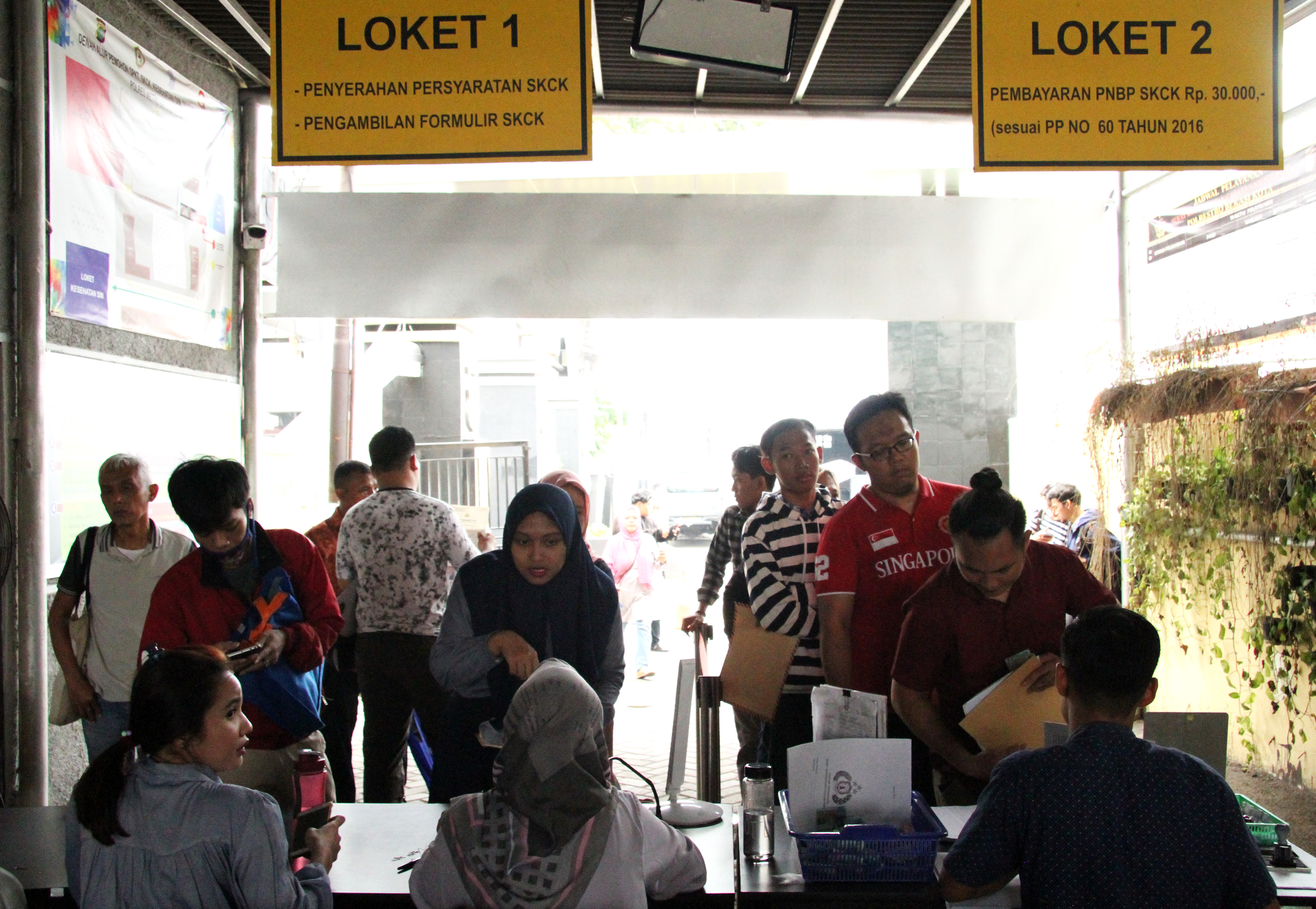 Petugas melayani pembuatan SKCK, di Mapolres Metro Bekasi Kota. Warga membuat SKCK untuk mendaftar sebagai CPNS.