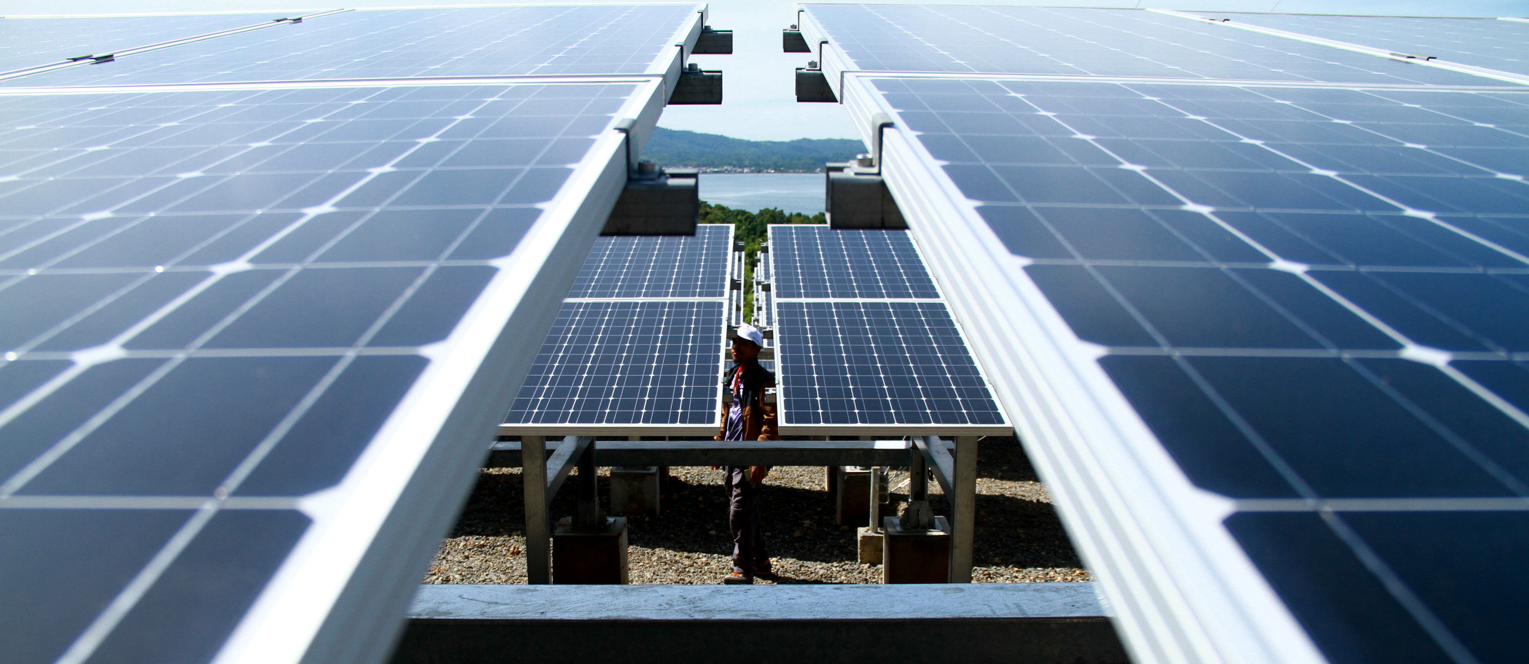 Petugas berjalan dekat solar panel Pembangkit Listrik Tenaga Surya (PLTS) yang akan diresmikan di Pulau Karampuang, Mamuju, Sulawesi Barat, 