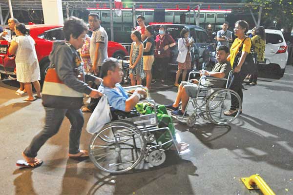 Sejumlah pasien dan keluarga berkumpul di area parkir Rumah Sakit Siloam saat terjadi gempa di Manado, Sulawesi Utara, Kamis (14/11) malam.