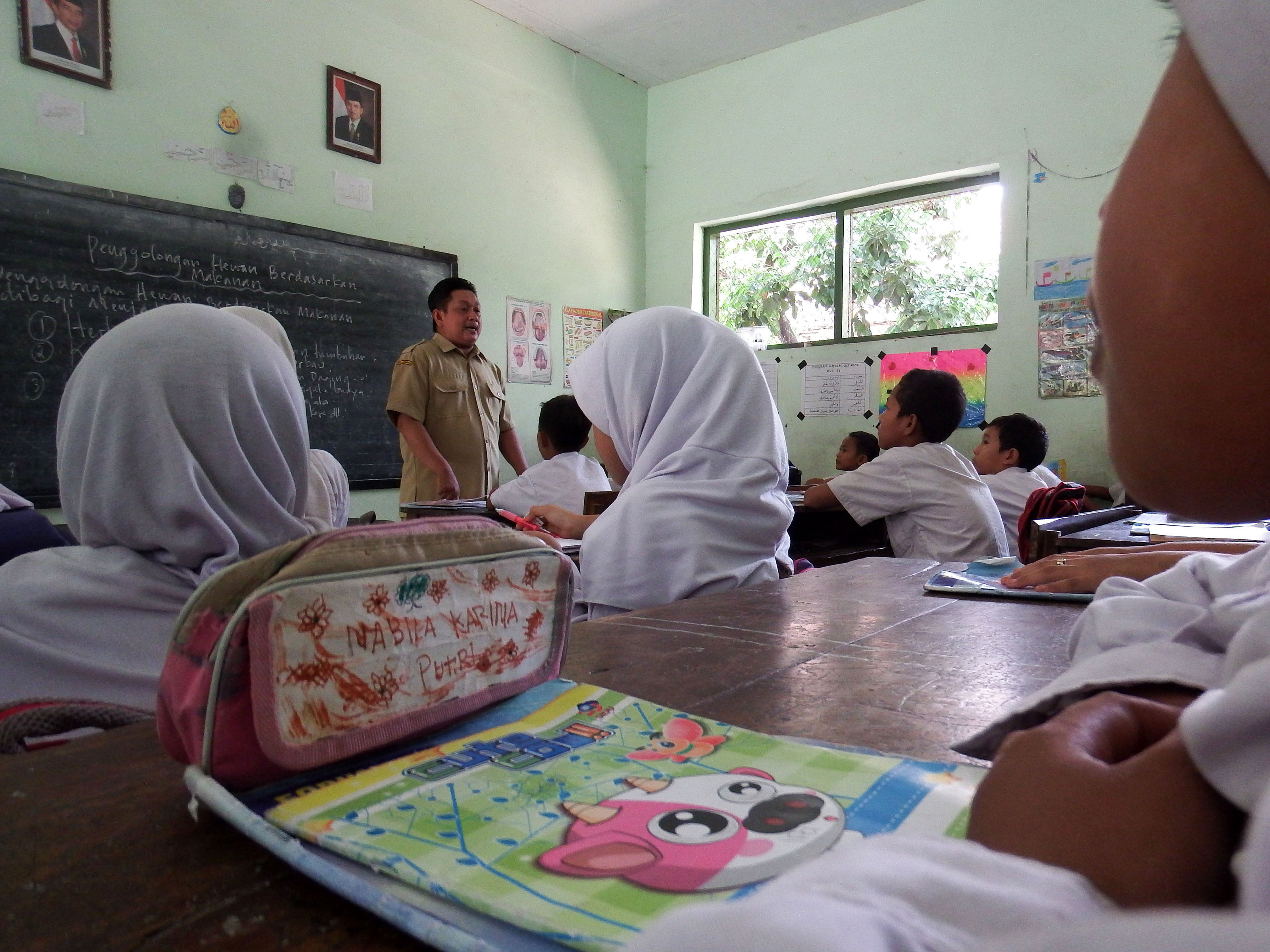 Seorang guru honorer melakukan proses belajar mengajar di Madrasah Ibtidaiyah Bandung III Jombang, Jawa Timur, Selasa (24/11)