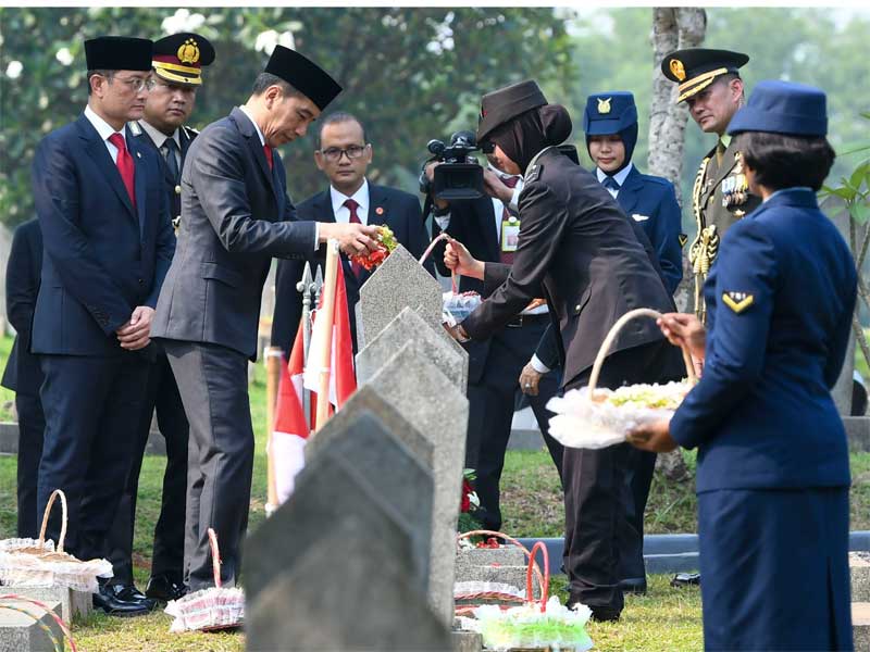 Presiden Joko Widodo (tengah) bersama Menteri Sosial Juliari Batubara (kedua kiri) melakukan tabur bunga seusai Upacara Ziarah Nasional.