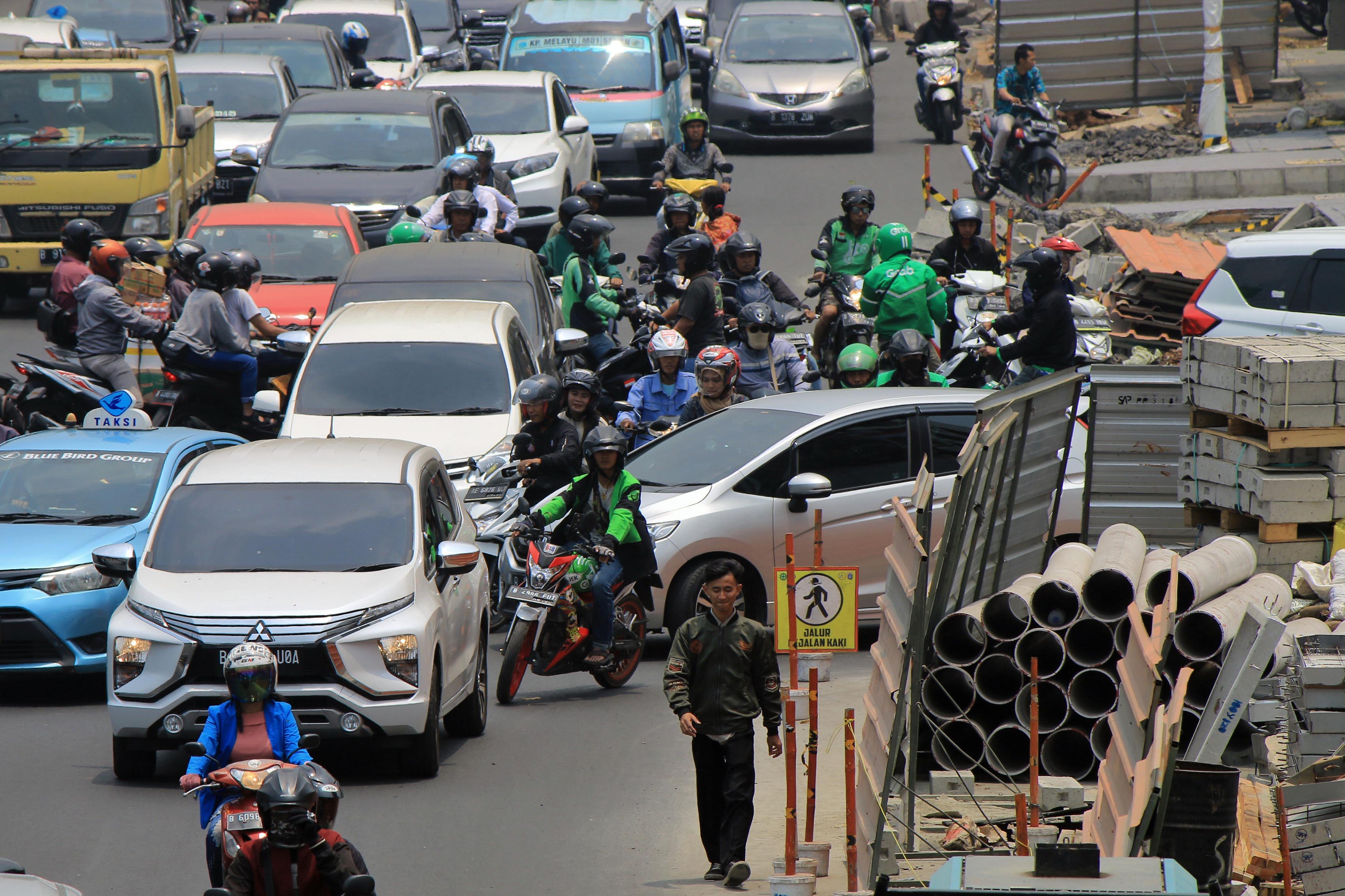 Antrean kendaraan saat melintasi pembangunan trotoar di Jalan Kramat Raya, Jakarta, Rabu (16/10)