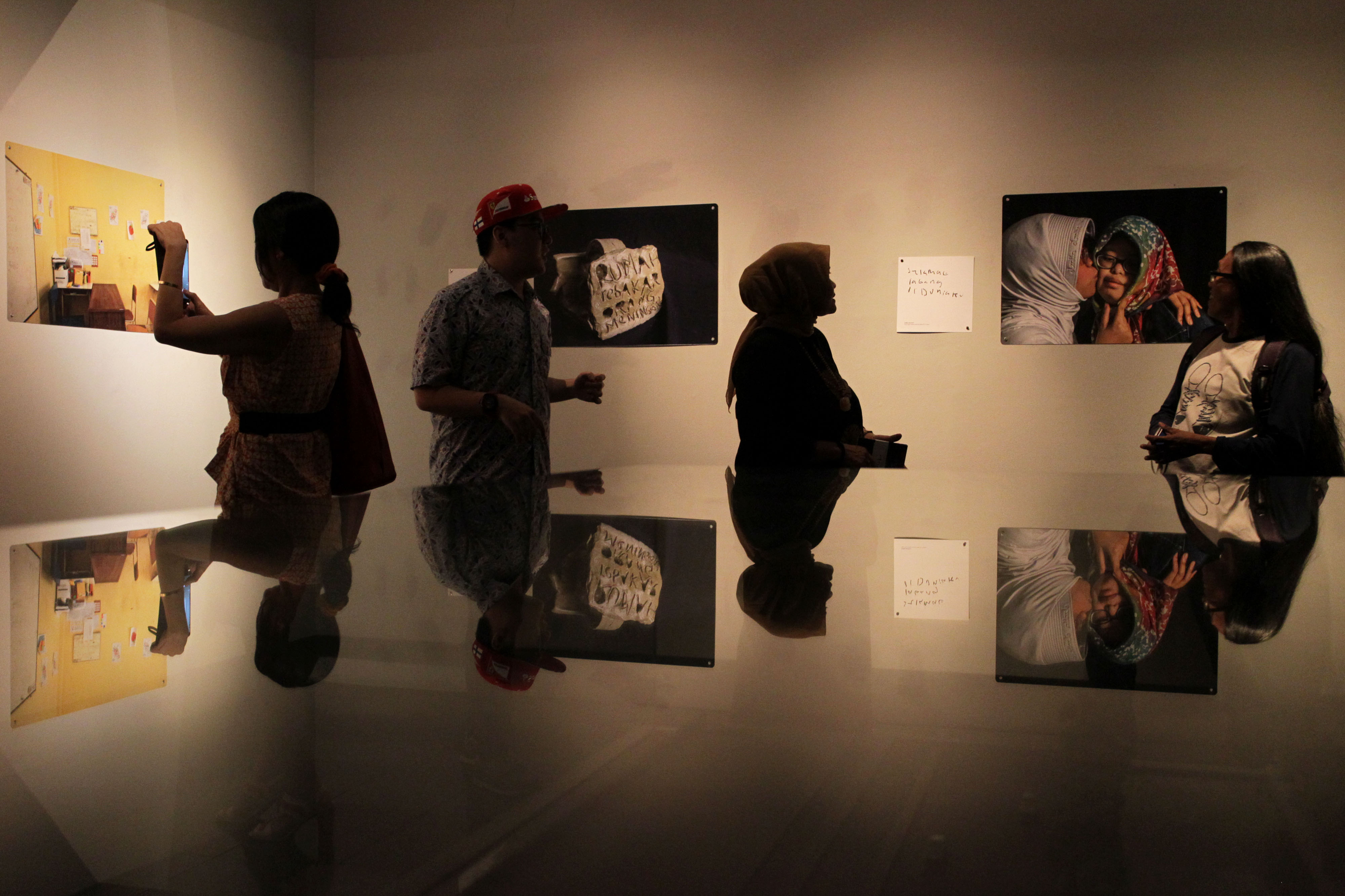 Pengunjung mengamati sejumlah foto karya siswa berkebutuhan khusus saat pembukaan pameran foto bertajuk Selamat Datang di Duniaku