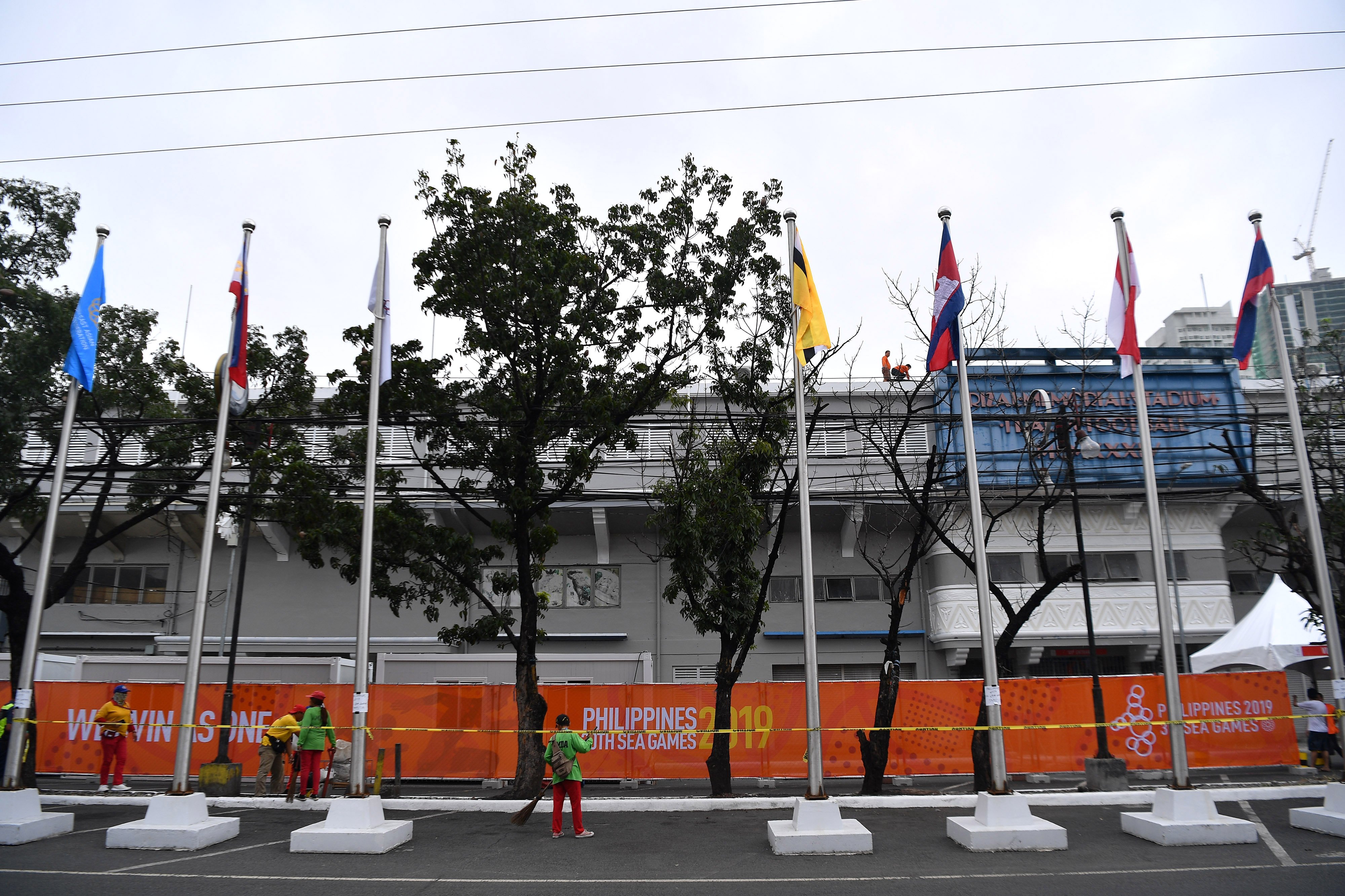 Pekerja menyapu jalanan di Stadion Rizal Memorial, Manila, Filipina,