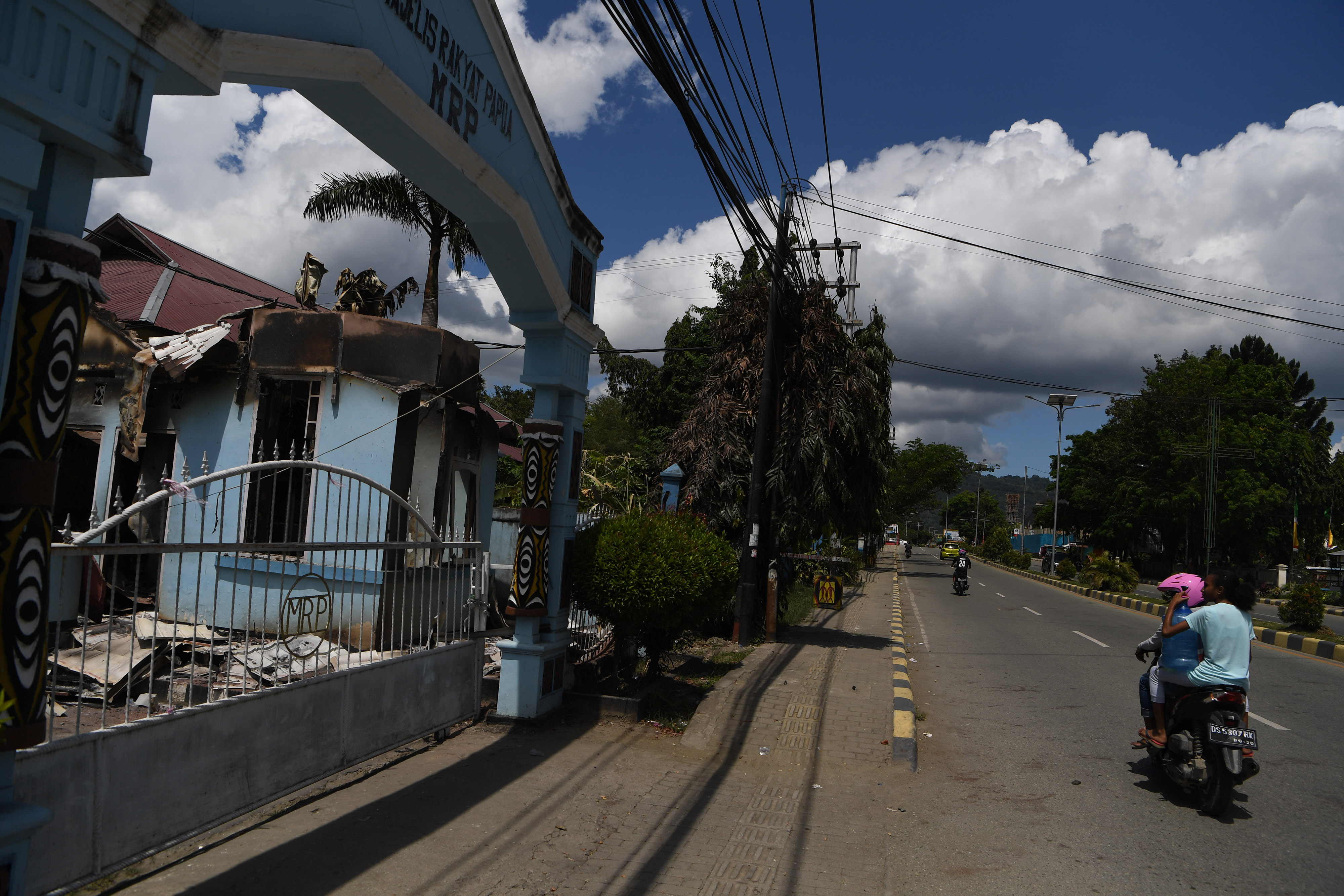 Pengendara melintas di depan bangunan Majelis Rakyat Papua yang terbakar di Jayapura, Papua, Sabtu (31/8). MRP tidak setuju pemekaran Papua