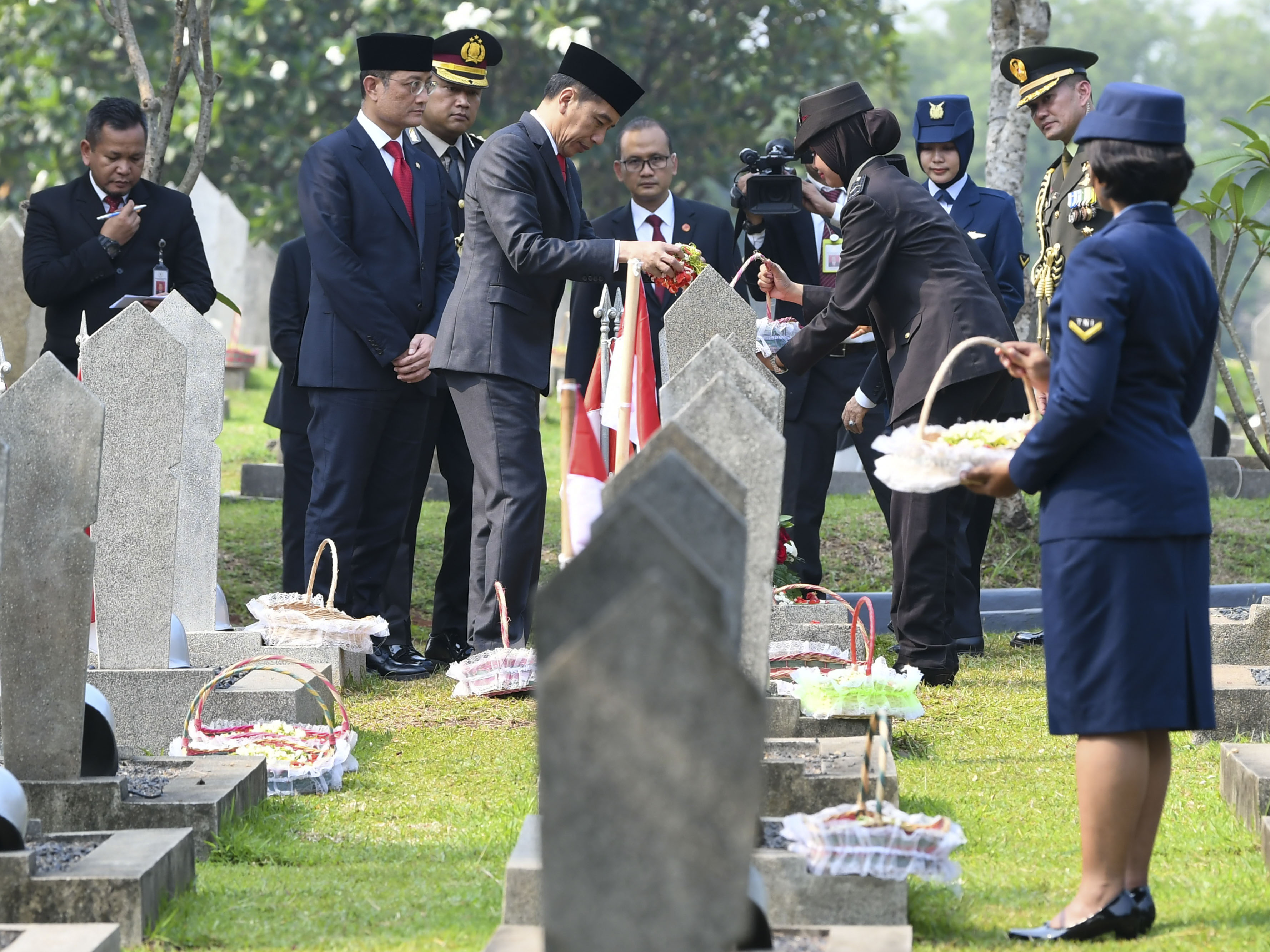 Presiden Joko Widodo (tengah) melakukan tabur bunga seusai Upacara Ziarah Nasional di Taman Makam Pahlawan Nasional Utama Kalibata, Jakarta