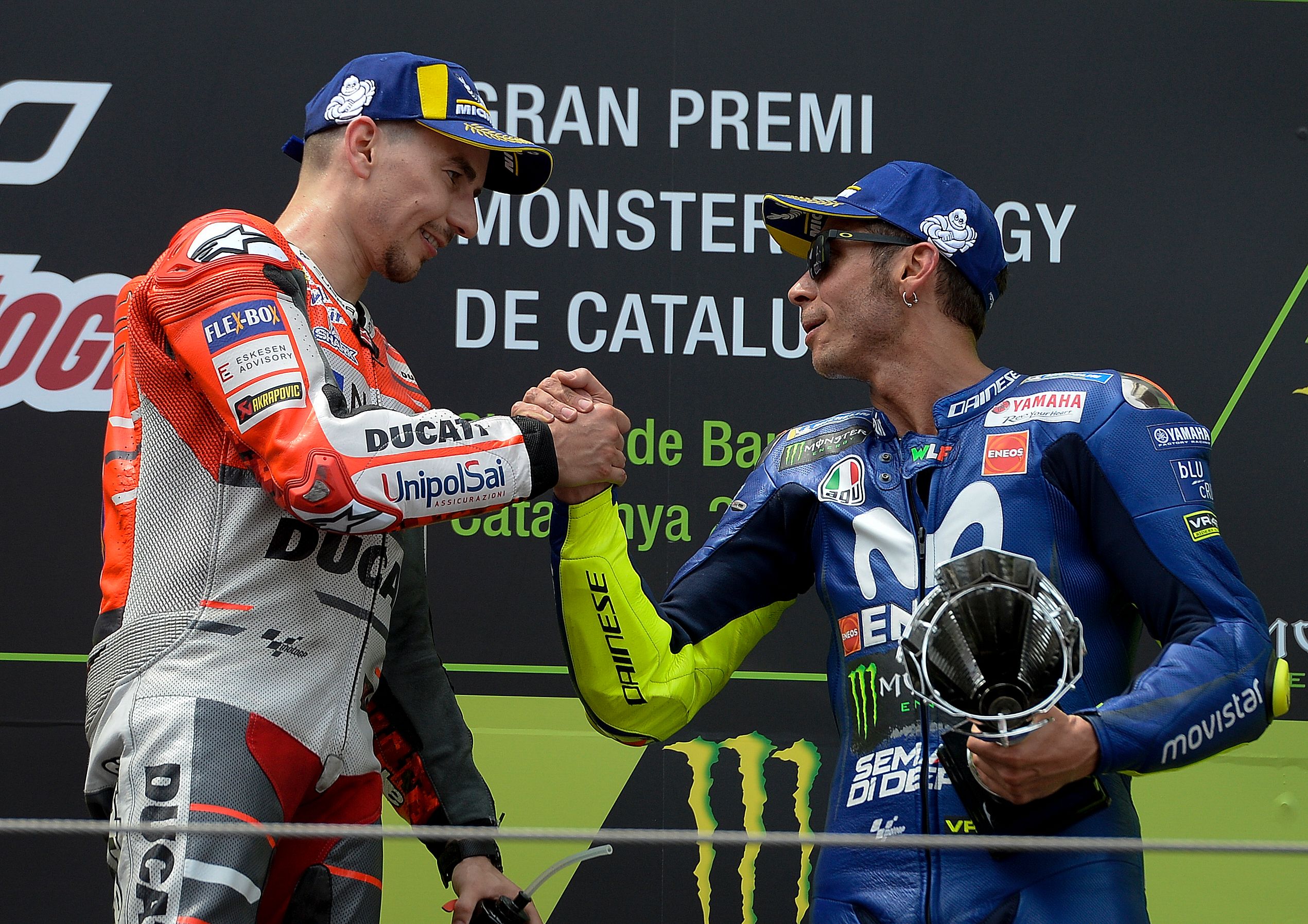 Jorge Lorenzo (kiri) berjabat tangan dengan Valentino Rossi