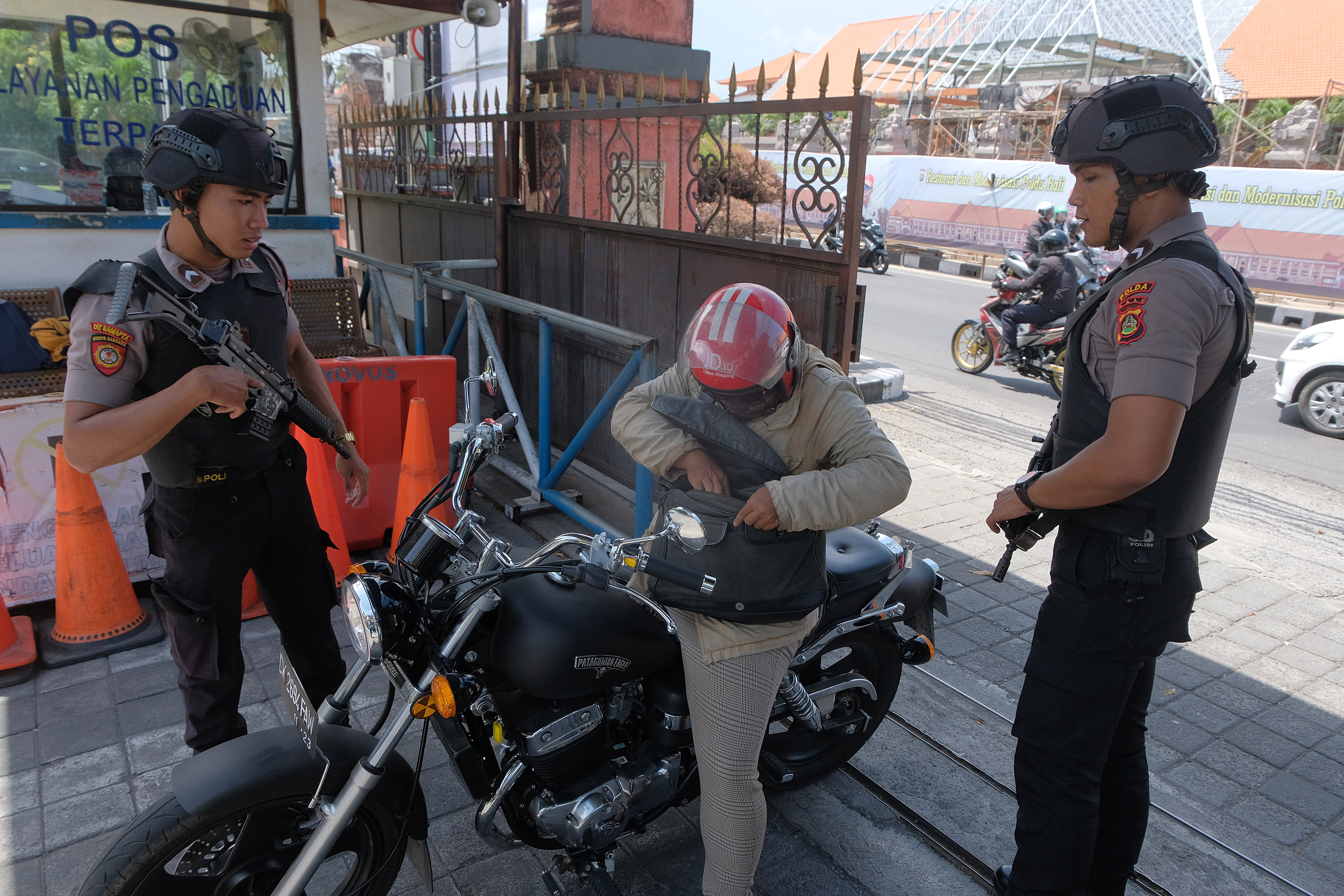 Polisi memeriksa pengendara sepeda motor yang akan masuk ke Mapolda Bali, Denpasar, Bali, Rabu (13/11/2019). 