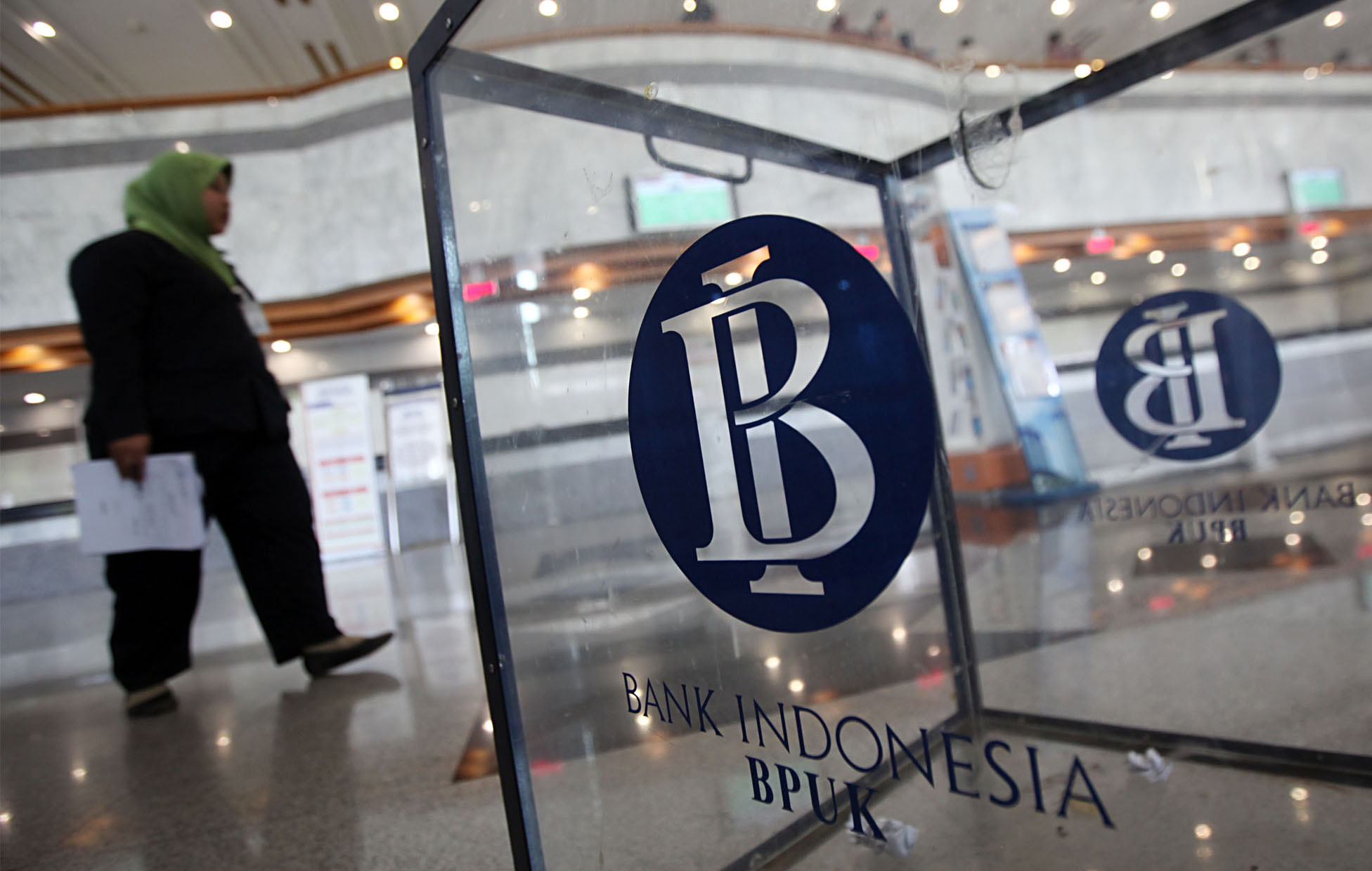   Seorang wanita melintas di dekat logo Bank Indonesia di Gedung C Bank Indonesia (BI), Jalan MH Thamrin, Jakarta Pusat, Selasa (13/9).