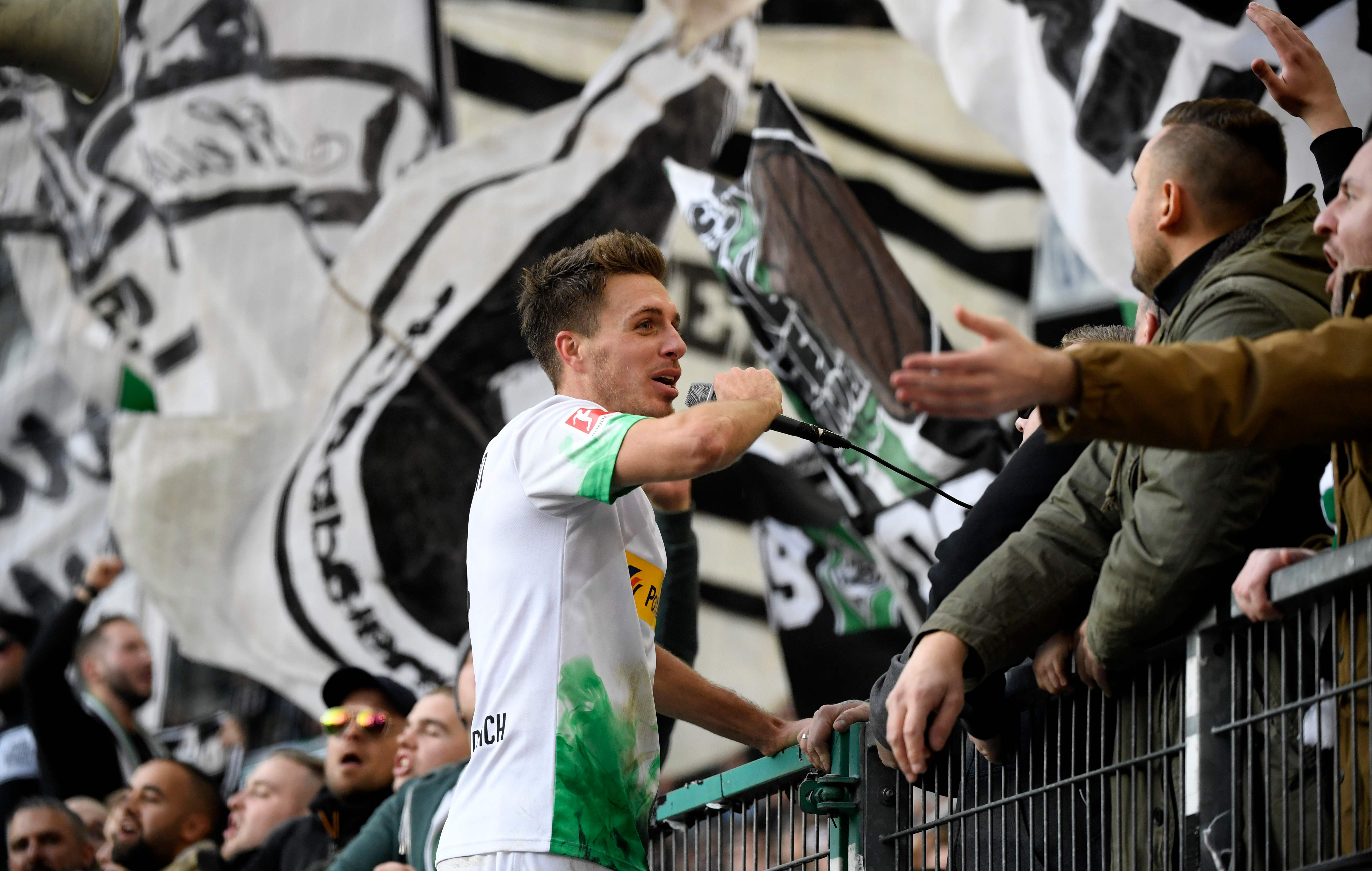 Gelandang Borussia Moenchengladbach Patrick Herrmann merayakan kemenangan atas Werder Bremen bersama para pendukung.