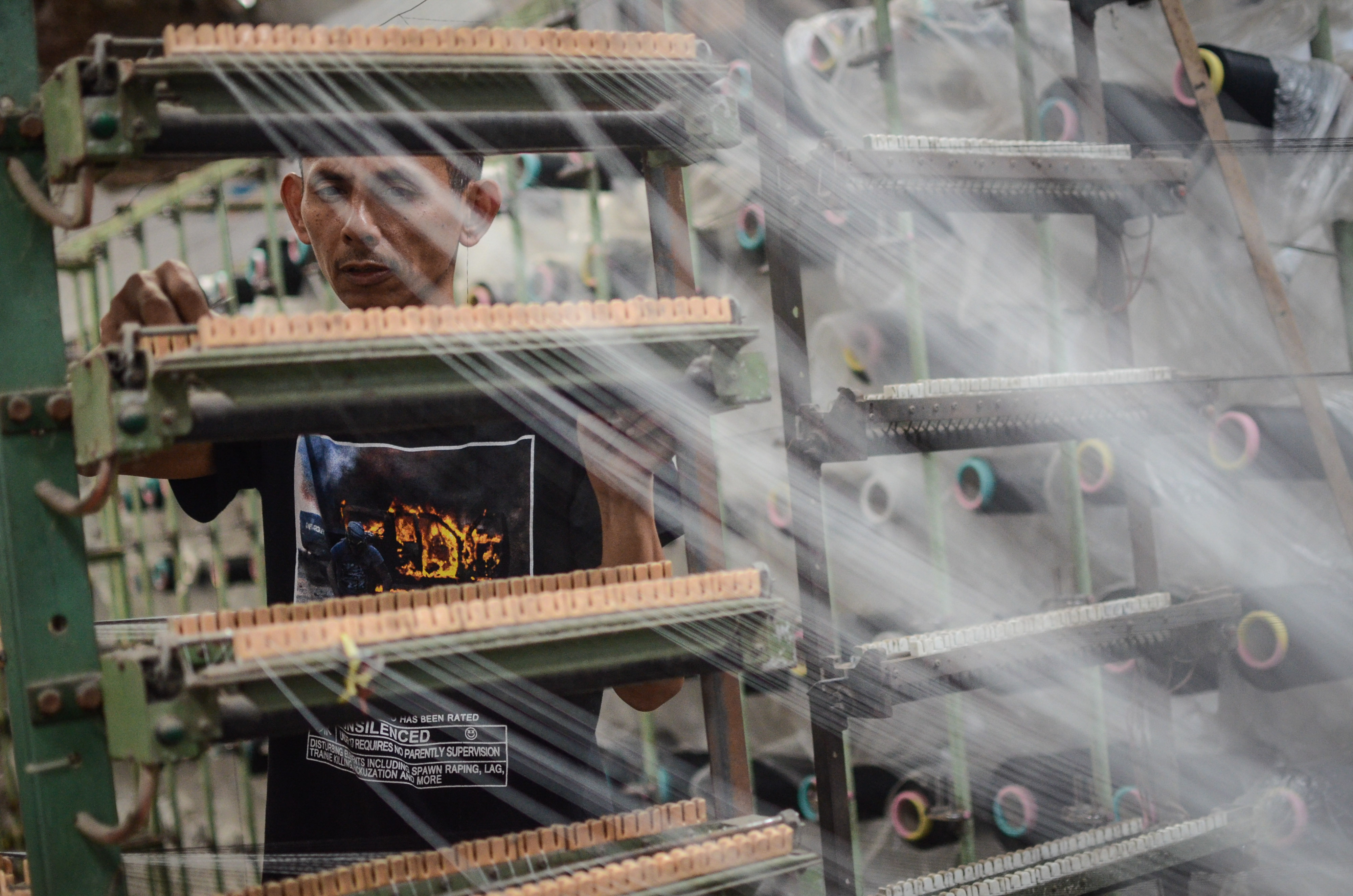 Pekerja menyelesaikan produksi kain sarung di Pabrik Tekstil Kawasan Industri Majalaya, Kabupaten Bandung, Jawa Barat, Jumat (4/1/2019)