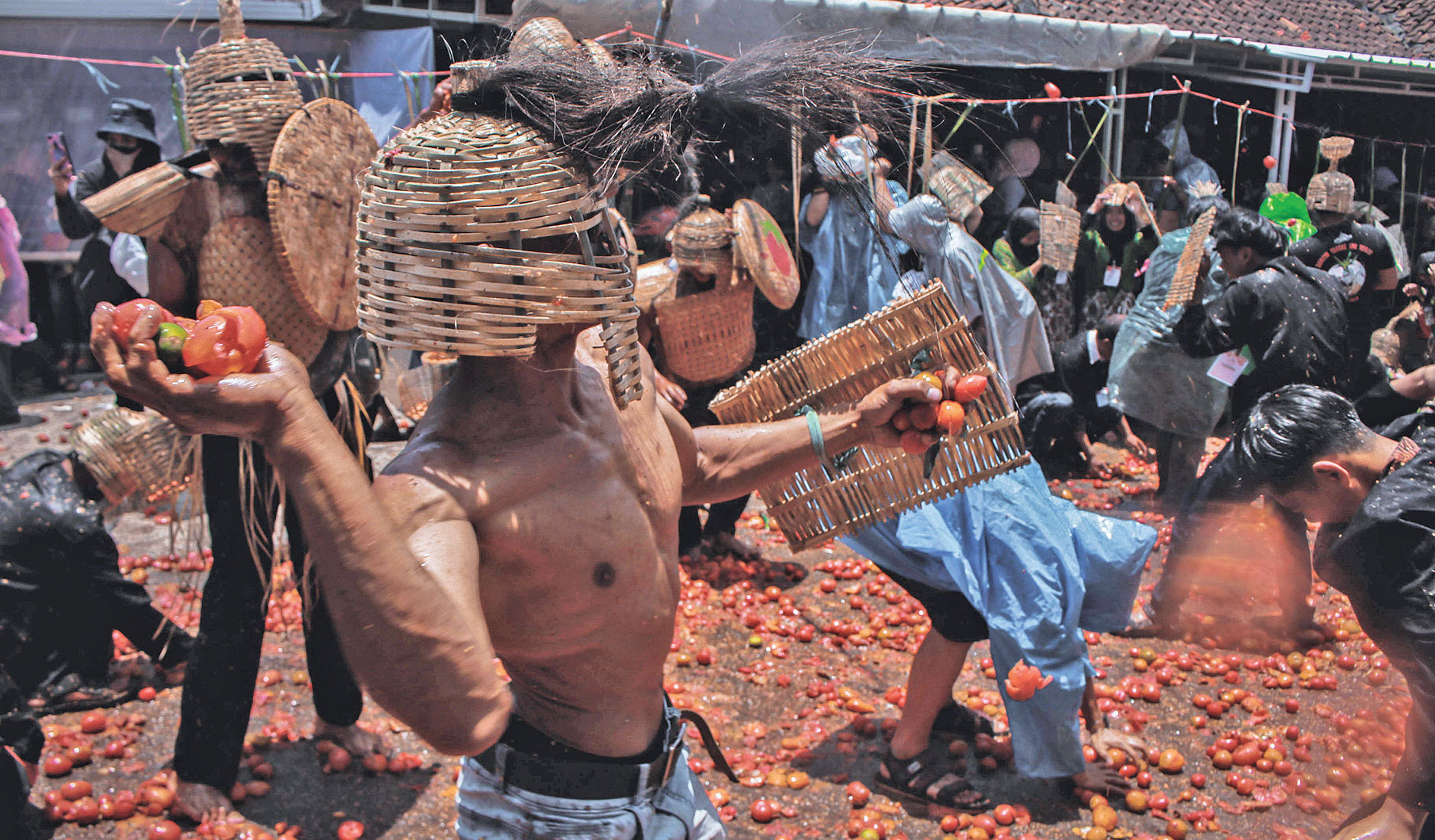 Warga saling melempar tomat saat mengikuti tradisi Rempug Tarung Adu Tomat.