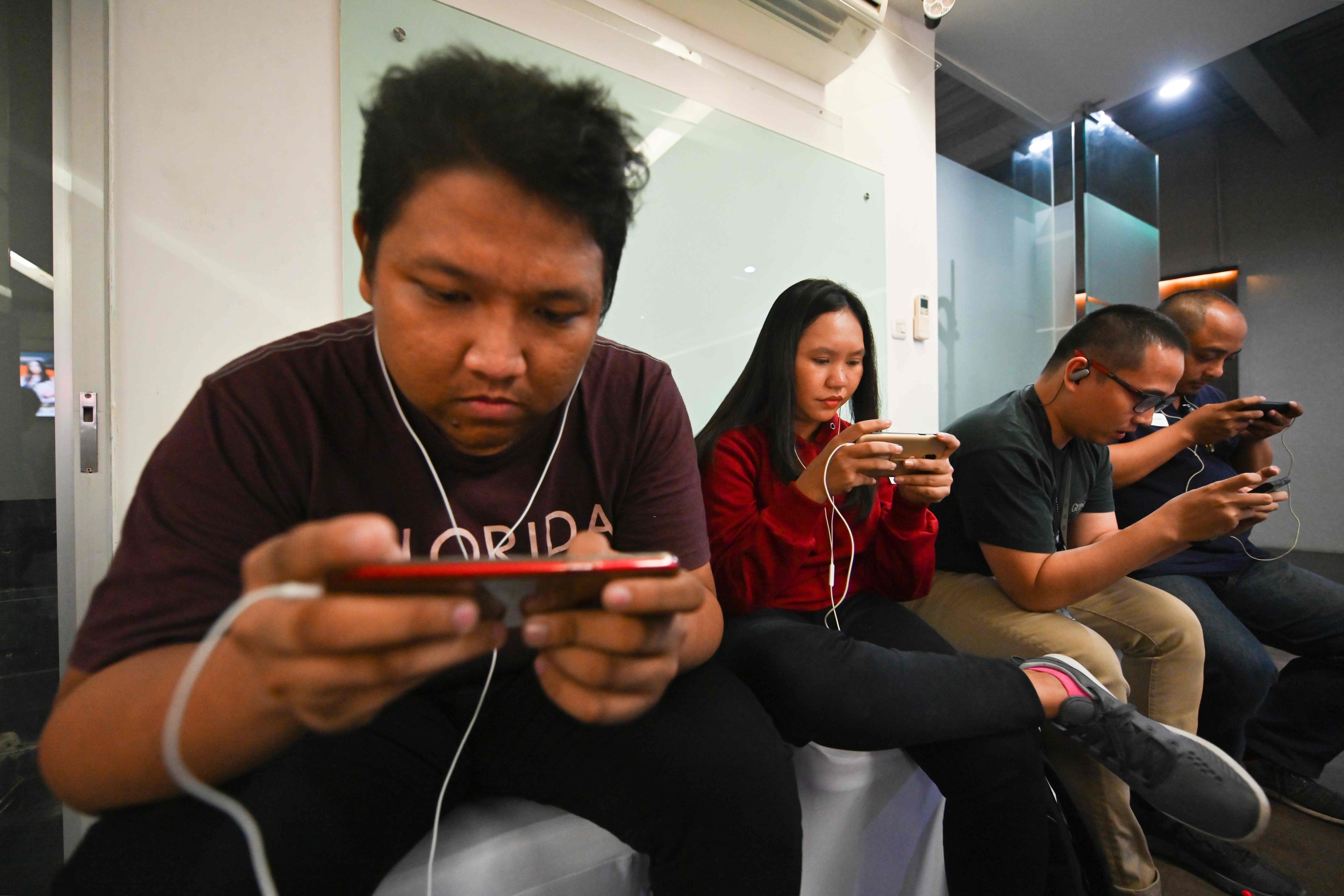 Ilustrasi: Sekelompok orang sedang bermain dengan gadjet mereka.