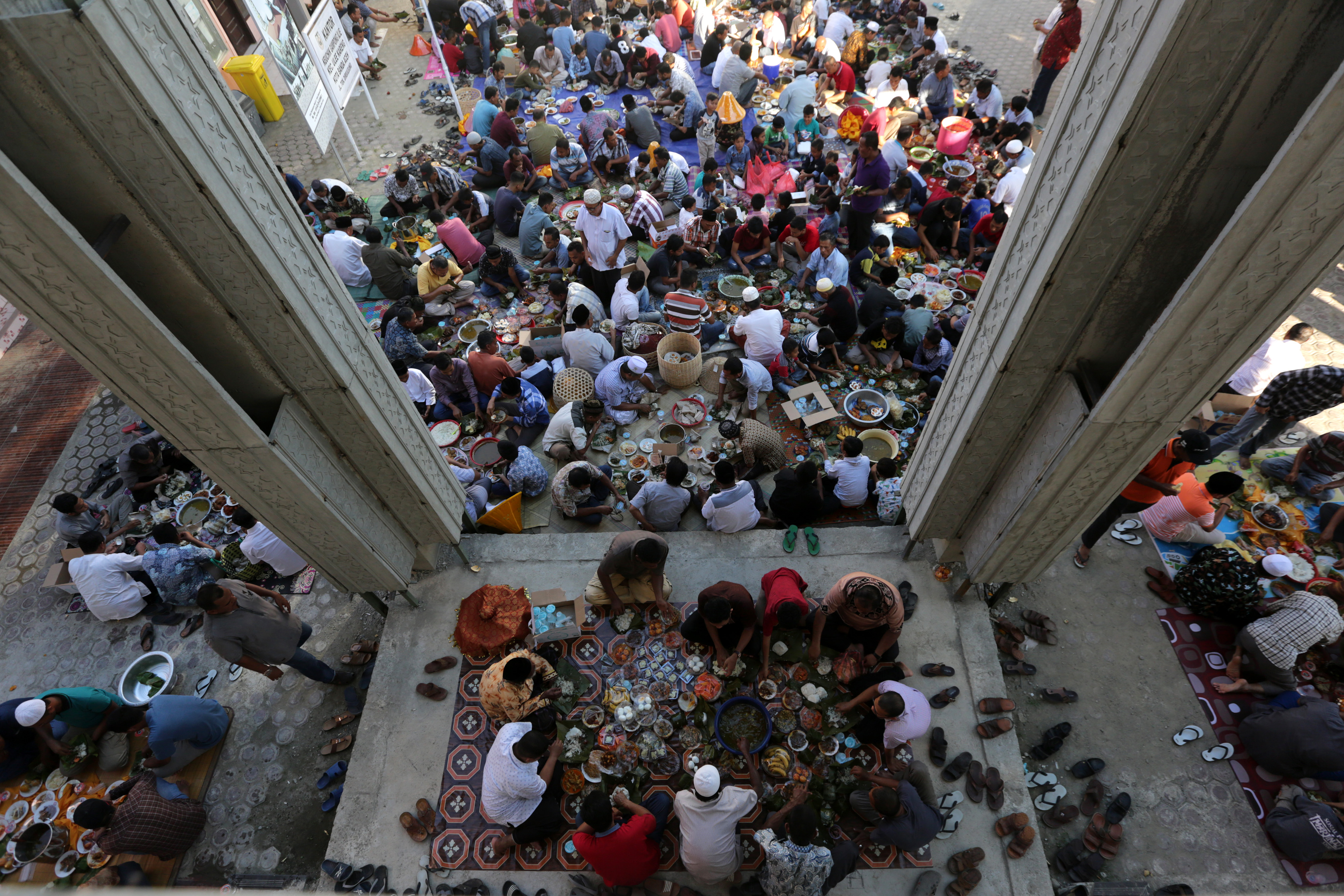 Warga makan bersama usai kenduri peringatan Maulid Nabi Muhammad saw. di Desa Ilie, Ulee Kareng, Banda Aceh, Aceh
