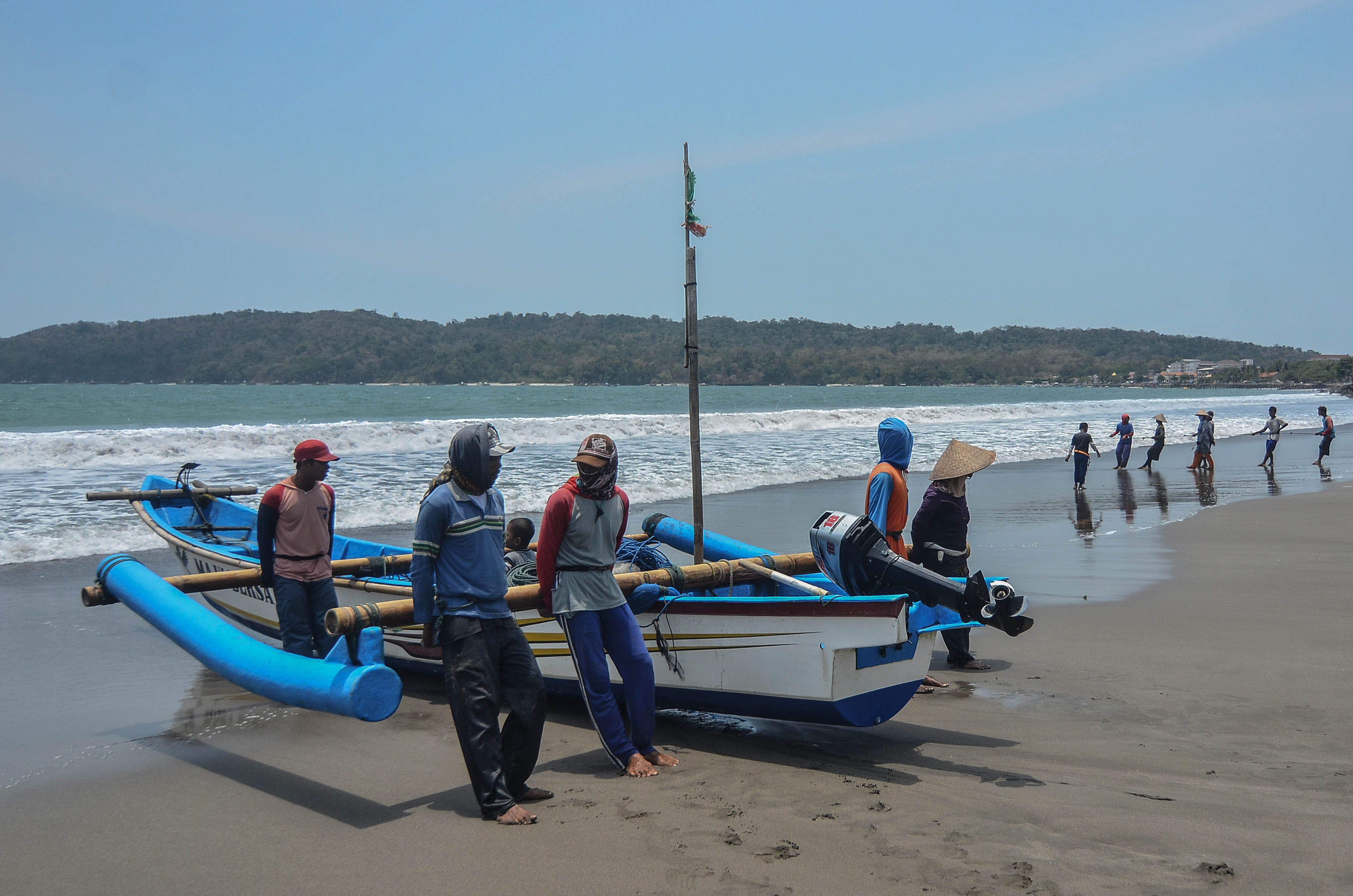 Sejumlah nelayan bergotong royong mendorong perahu berkapasitas tujuh Gross Tonnage (GT) di Pesisir Pantai Timur Pangandaran, Jawa Barat