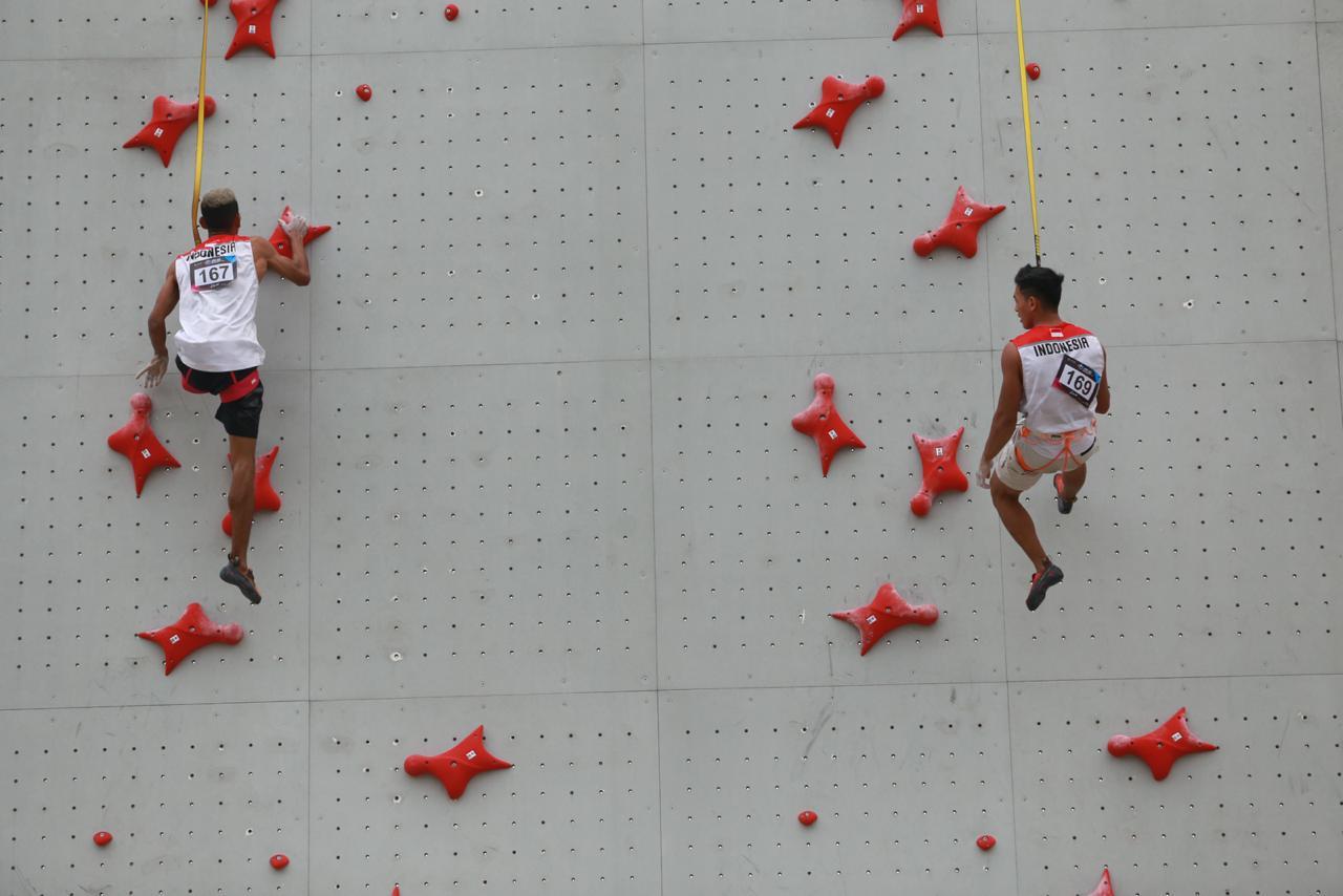 Dua atlet panjat tebing Indonesia tengah beraksi di nomor speed relay putra.