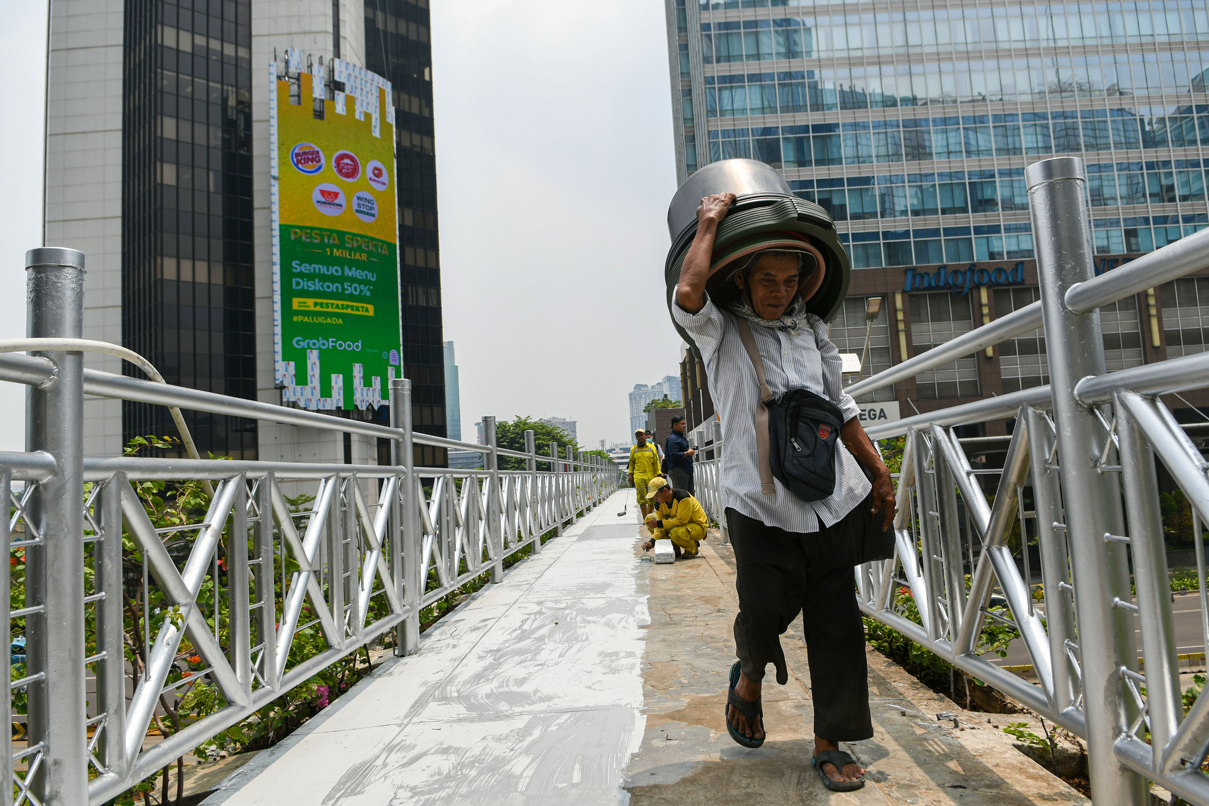  Pejalan kaki melintas di jembatan penyeberangan orang (JPO) yang tidak beratap di Jalan Sudirman, Jakarta, Rabu (6/11).