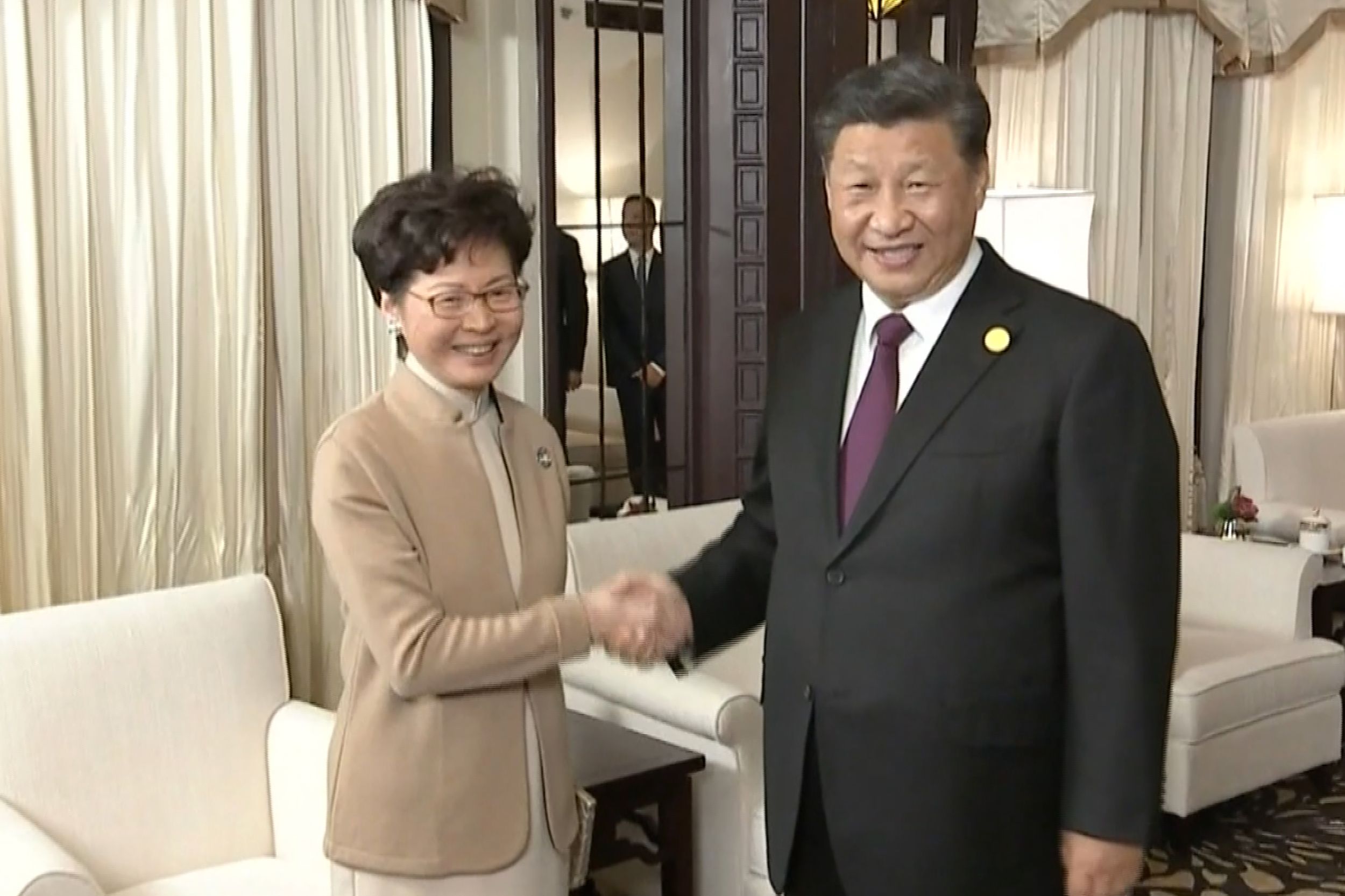 Video yang dirilis China Central Television (CCTV) menunjukkan Presiden Xi Jinping (kakan) bersalaman dengan Pemimpin Hong Kong Carie Lam.