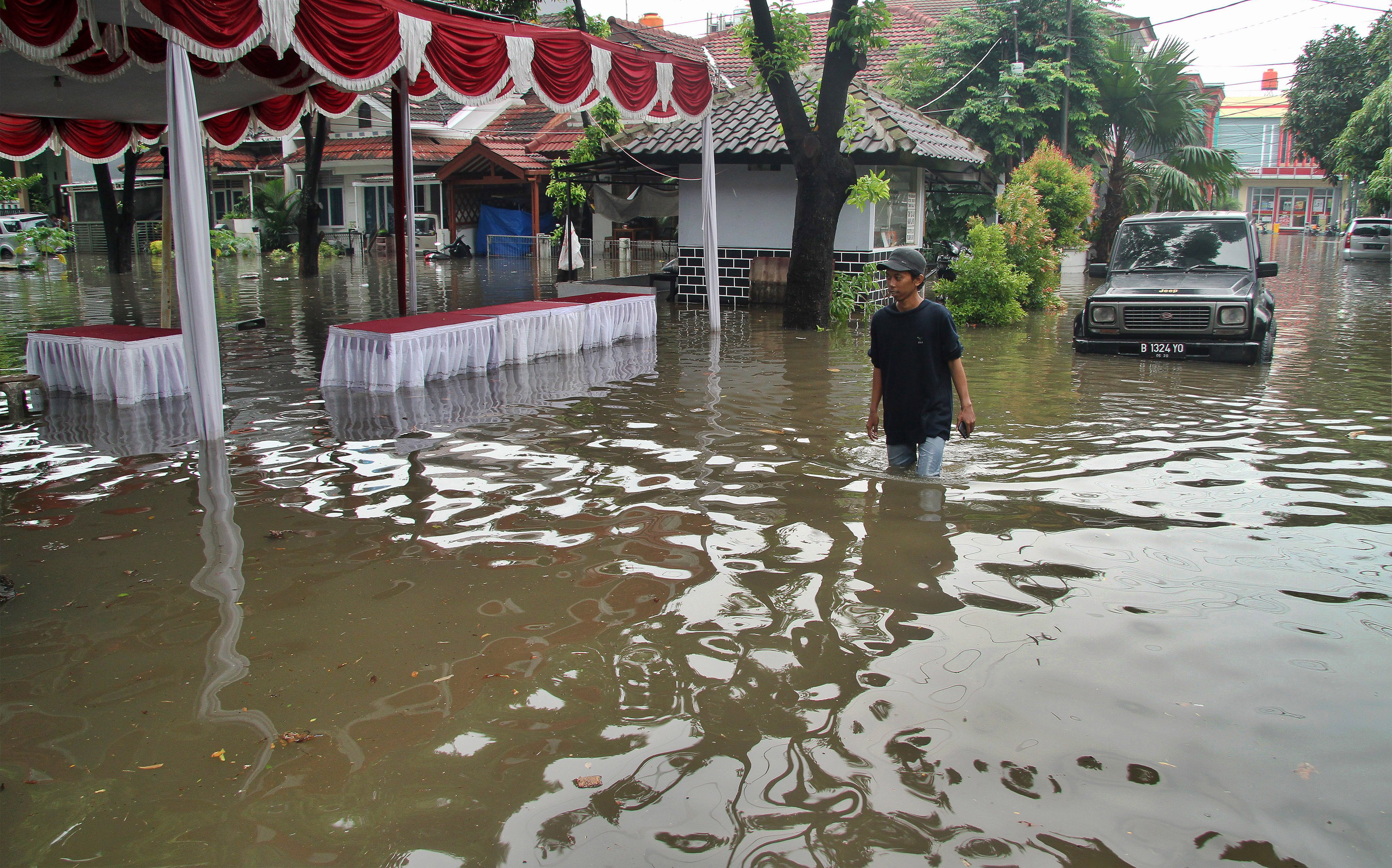 Warga menerobos banjir yang menggenangi Perumahan Galaxy di Bekasi, Jawa Barat.