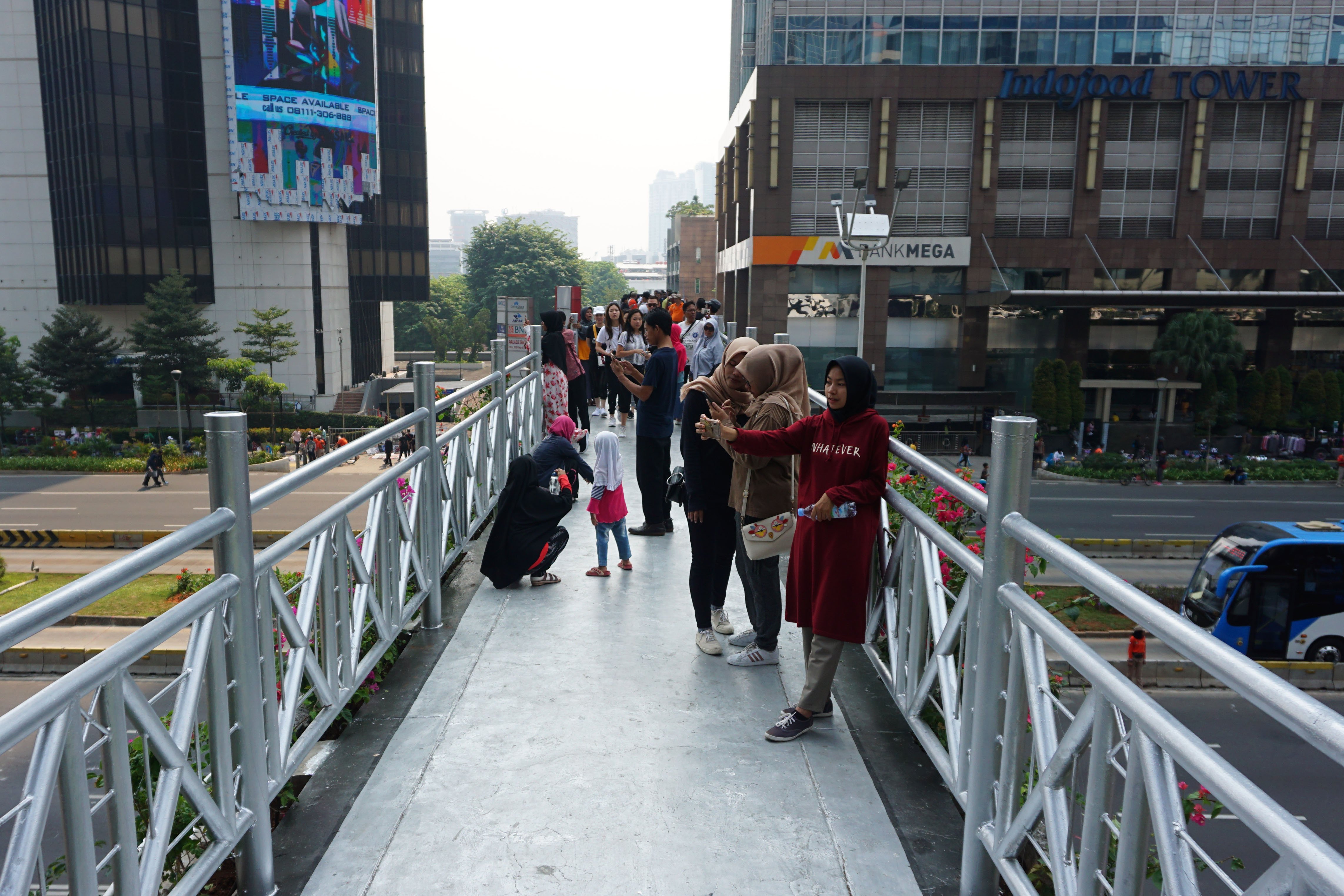 Warga memadati Jembatan Penyebrangan Orang (JPO) tanpa atap saat Hari Bebas Kendaraan Bermotor (HBKB) di kawasan Sudirman