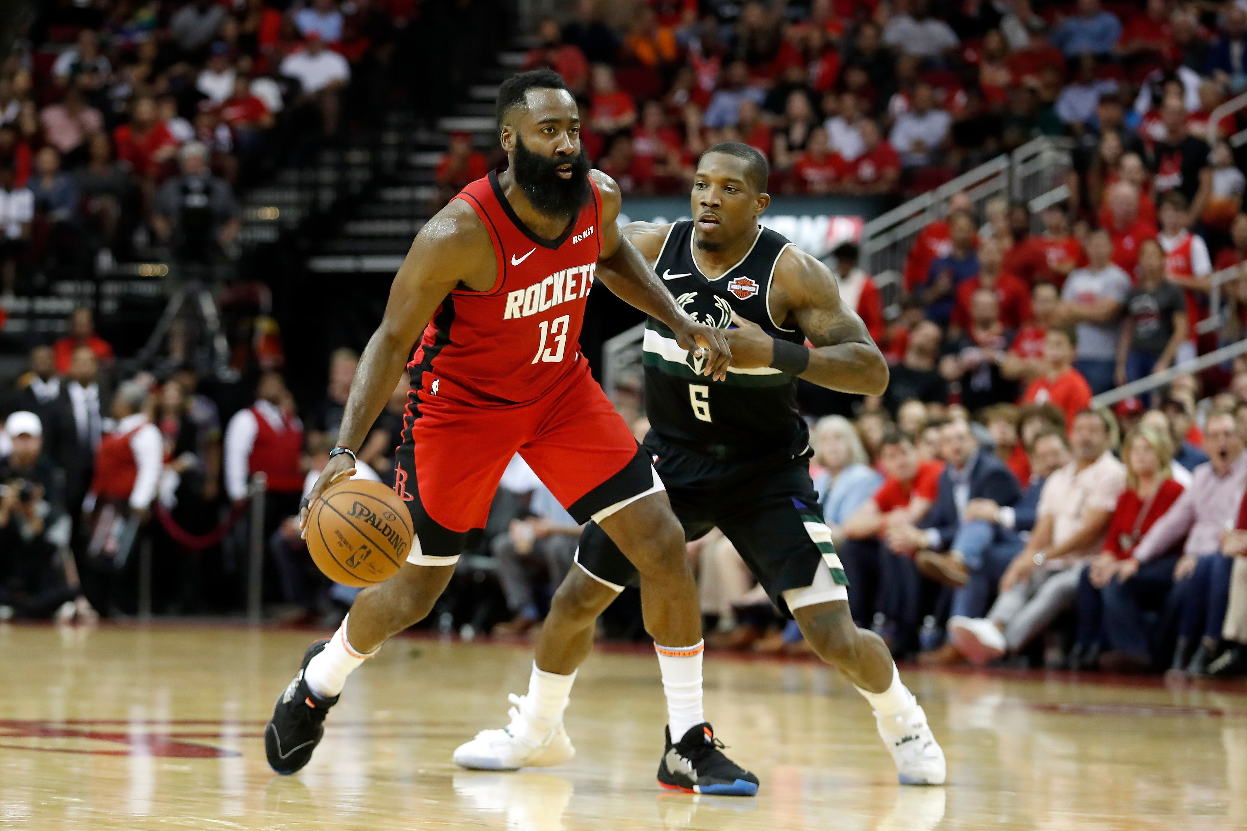 James Harden # 13 dari Houston Rockets menggiring bola yang dibela Eric Bledsoe # 6 dari Milwaukee Bucks di babak kedua di Toyota Center  
