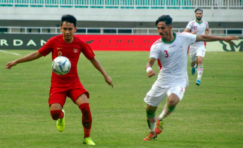 Pesepak bola timnas U-23 Indonesia Witan Sulaeman (kiri) berebut bola dengan pesepak bola U-23 Iran Mohammad Mioslemipour (kanan).