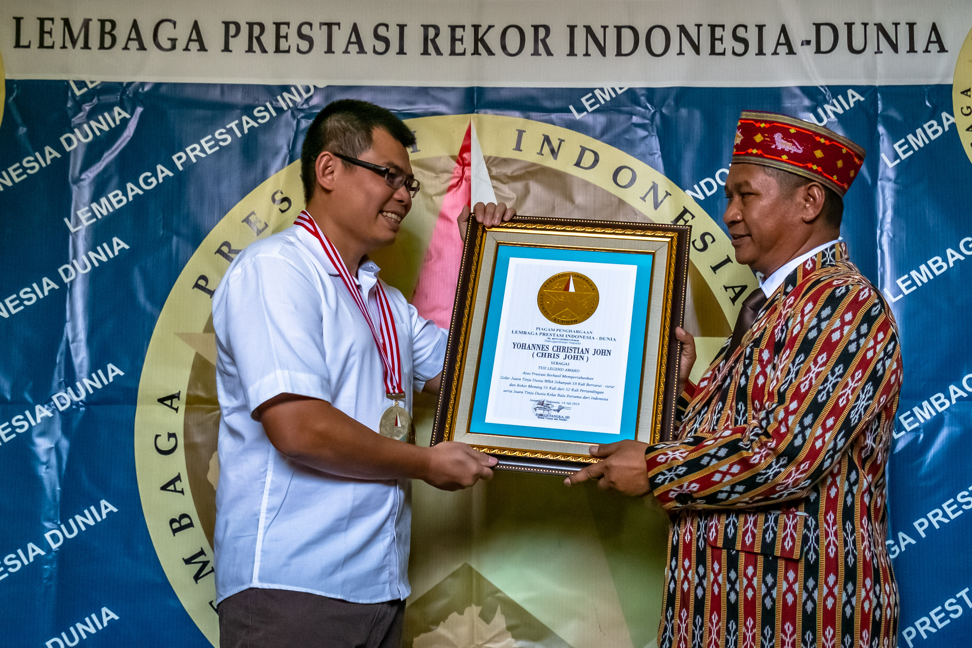 Mantan petinju Indonesia, Chris John (kiri), menerima penghargaan The Legend Award dari Lembaga Prestasi Indonesia-Dunia 