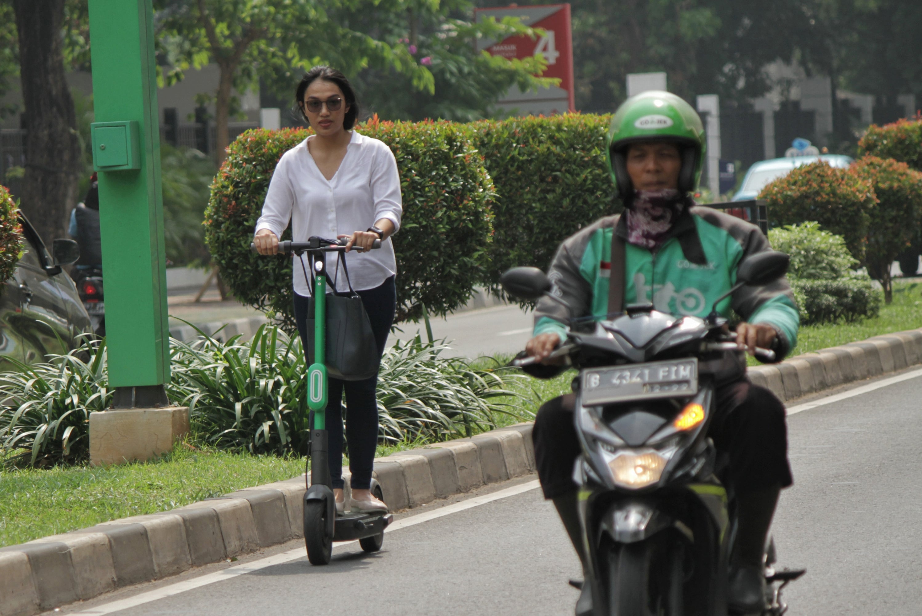 Sejumlah warga menggunakan skuter listrik Grab Wheels di Kawasan FX Sudirman, Jakarta Pusat, Rabu (13/11/2019).