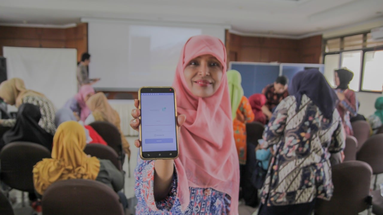 Seorang warga menunjukkan aplikasi HP Kader di ponsel miliknya.