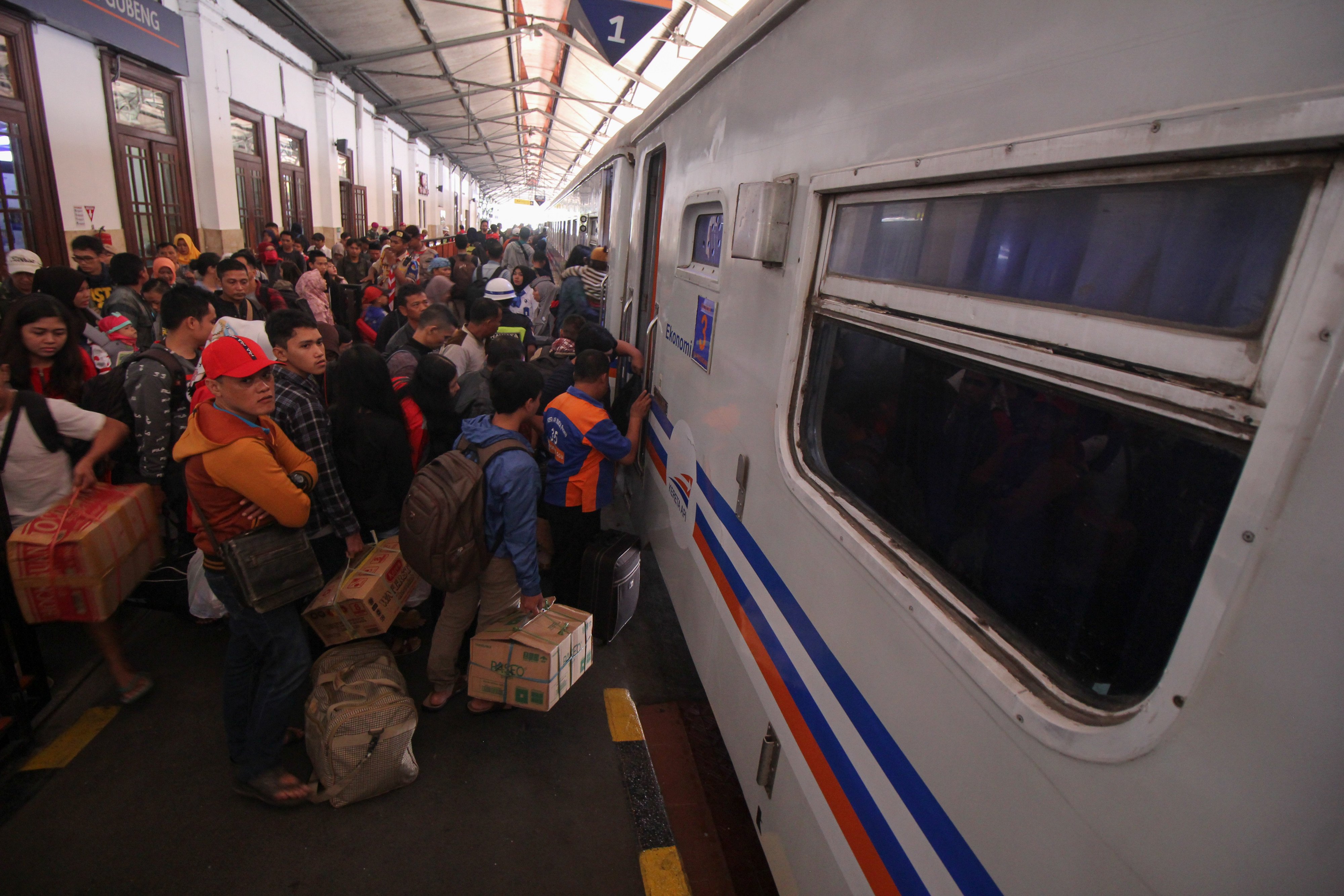 Penumpang antre masuk ke gerbong kereta api di Stasiun Gubeng Surabaya, Jawa Timur
