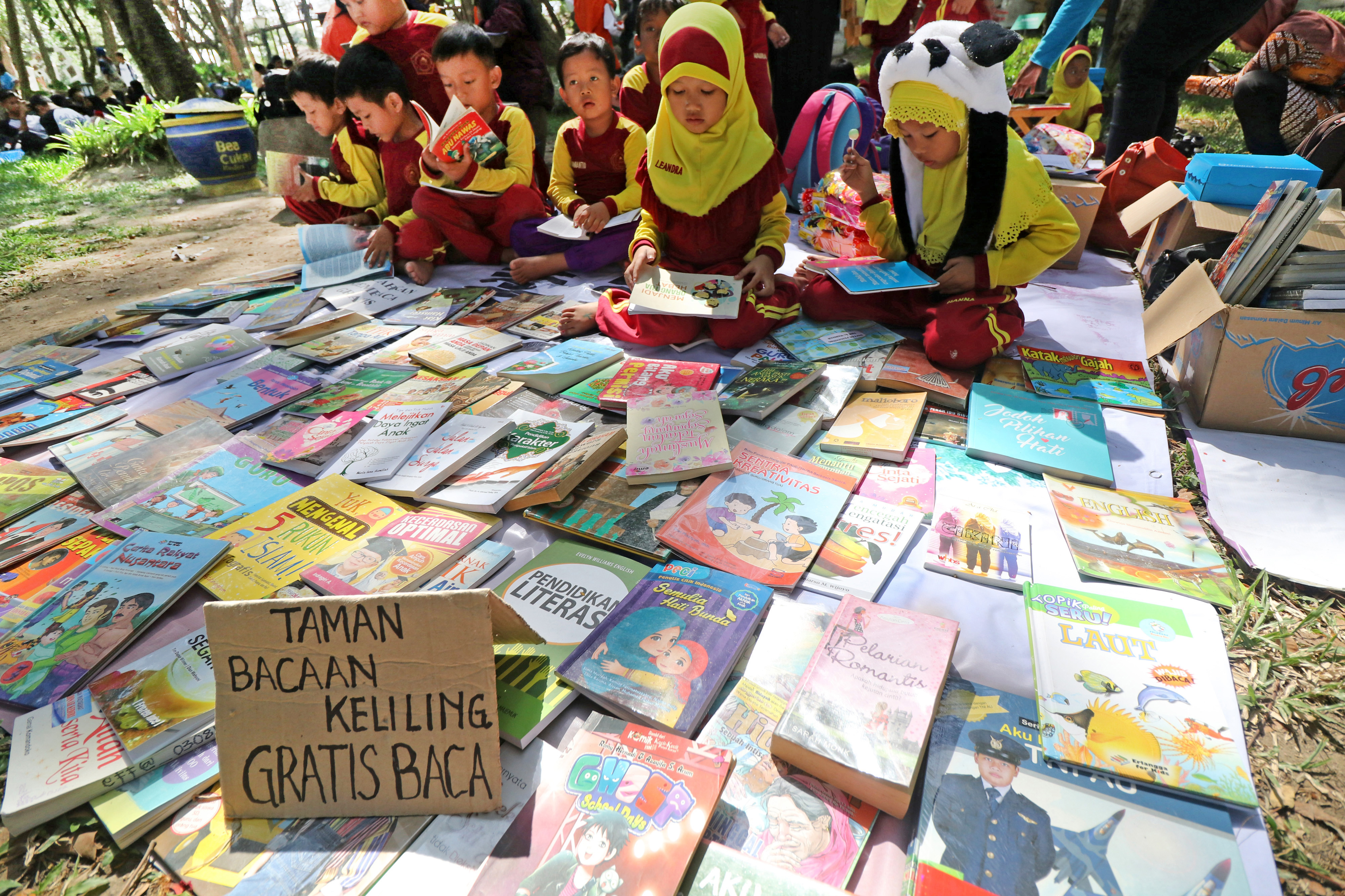 Sejumlah pelajar membaca buku bacaan saat mengikuti kegiatan tukar buku di Hutan Kota Joyoboyo, Kota Kediri, Jawa Timur, Sabtu (16/11/2019)