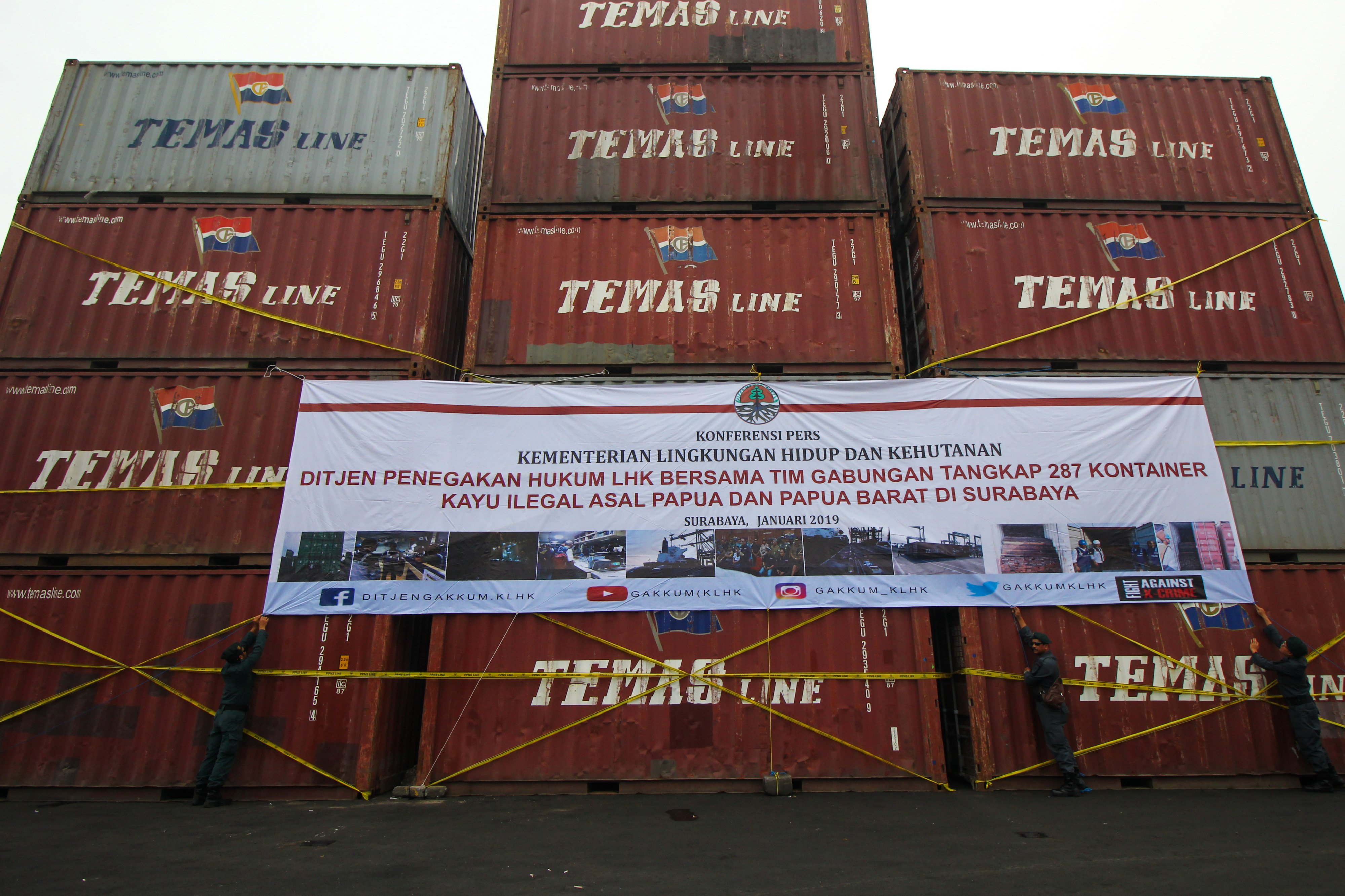  Petugas memasang spanduk pada kontainer yang berisi kayu ilegal di Terminal Teluk Lamong, Surabaya, Jawa Timur, Rabu (16/1/2019).