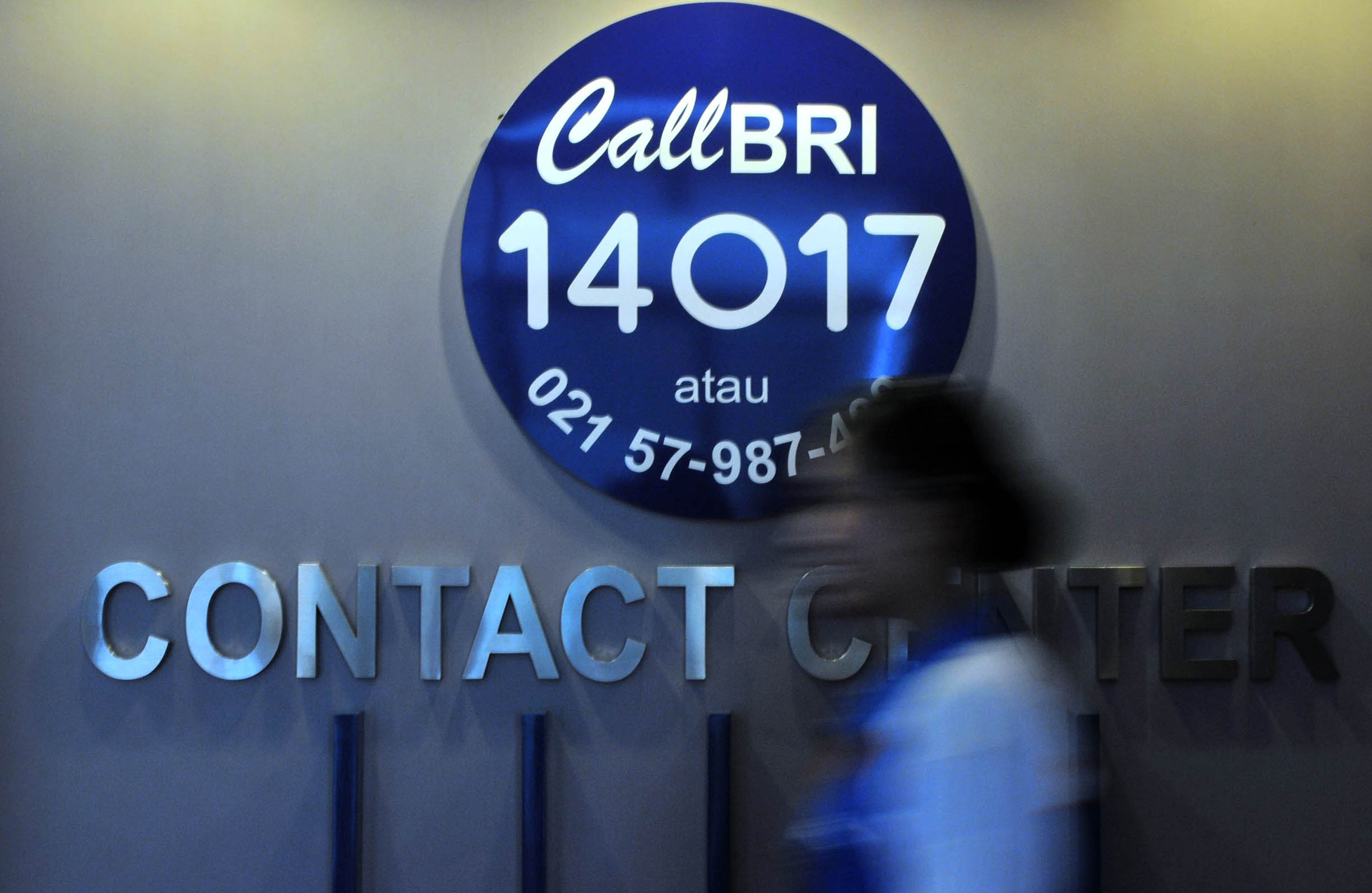 Seorang petugas call BRI melintas di depan logo Call BRI di BRI cabang Tanah Abang, Jakarta, Selasa (1/2). 