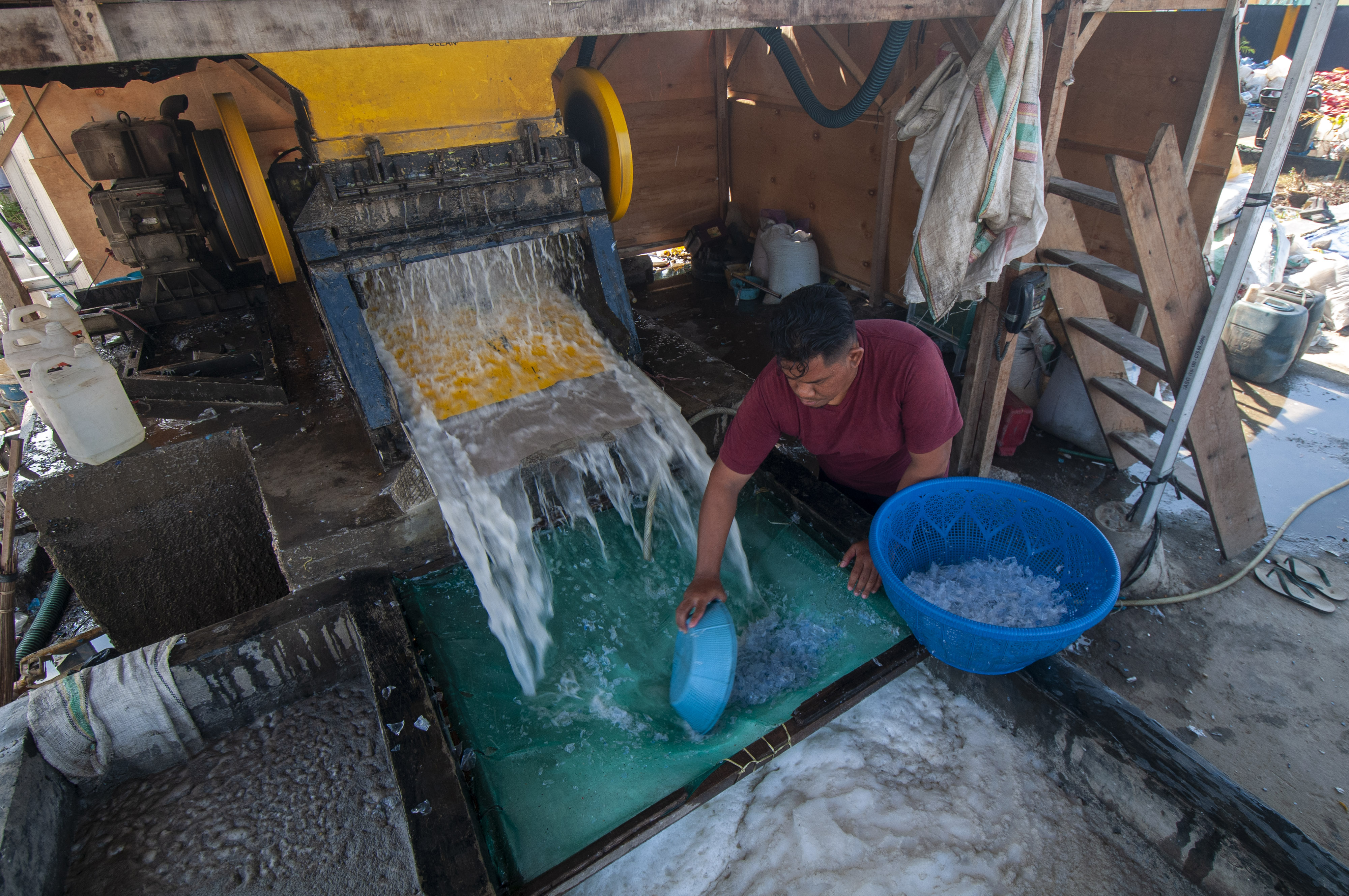 Pekerja mengumpulkan biji sampah plastik yang telah dicacah, di industri pengolahan sampah palstik Duta Recycling, di Palu, Sulawesi Tengah
